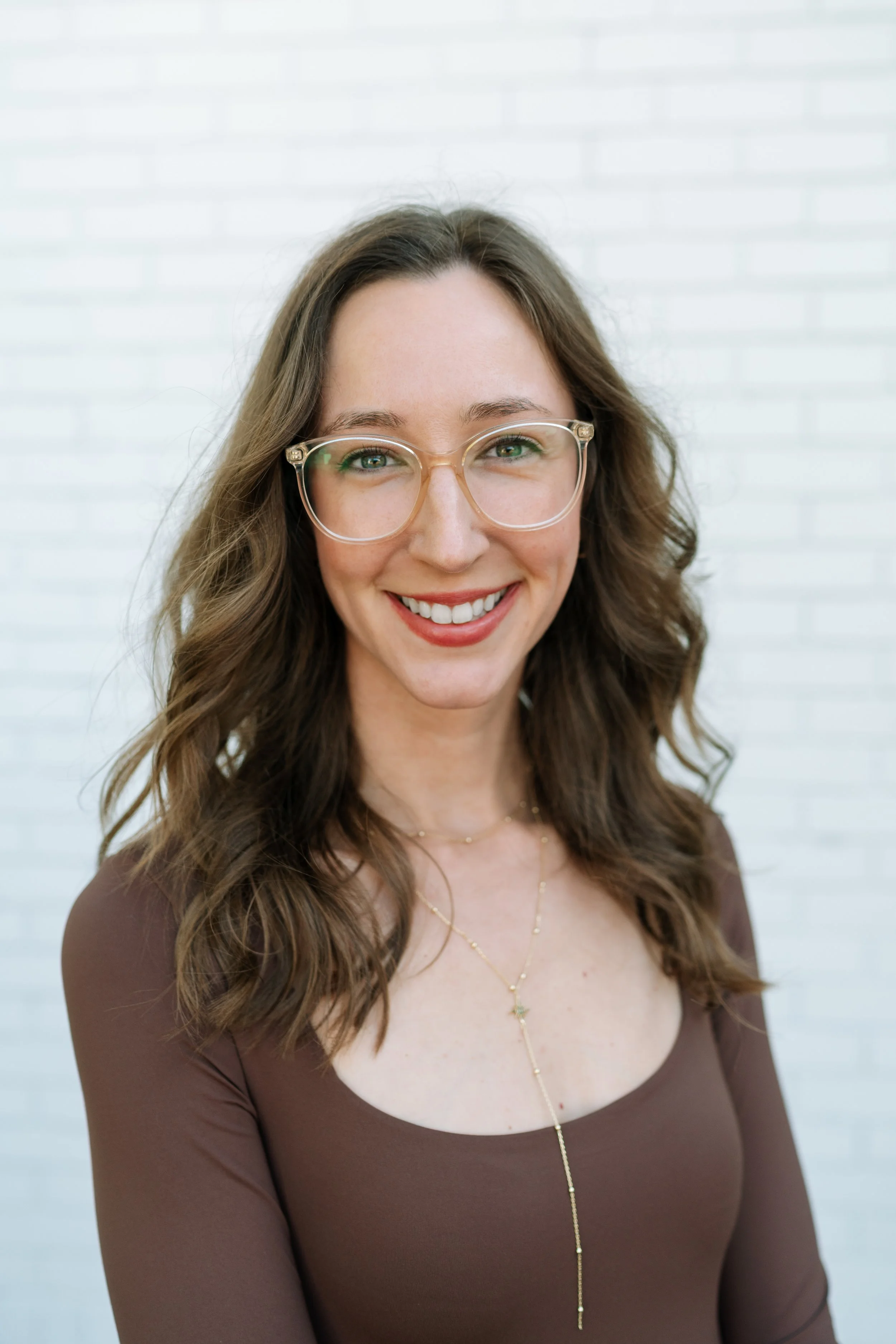 Candice is a woman with light brown hair and glasses in a black top