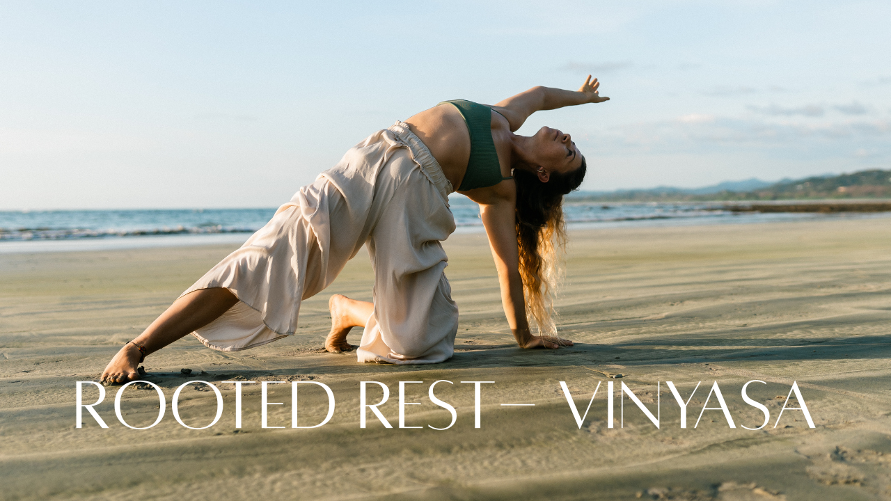 Woman practicing yoga on the beach with the ocean and sky in the background, wearing beige pants and a green sports bra.