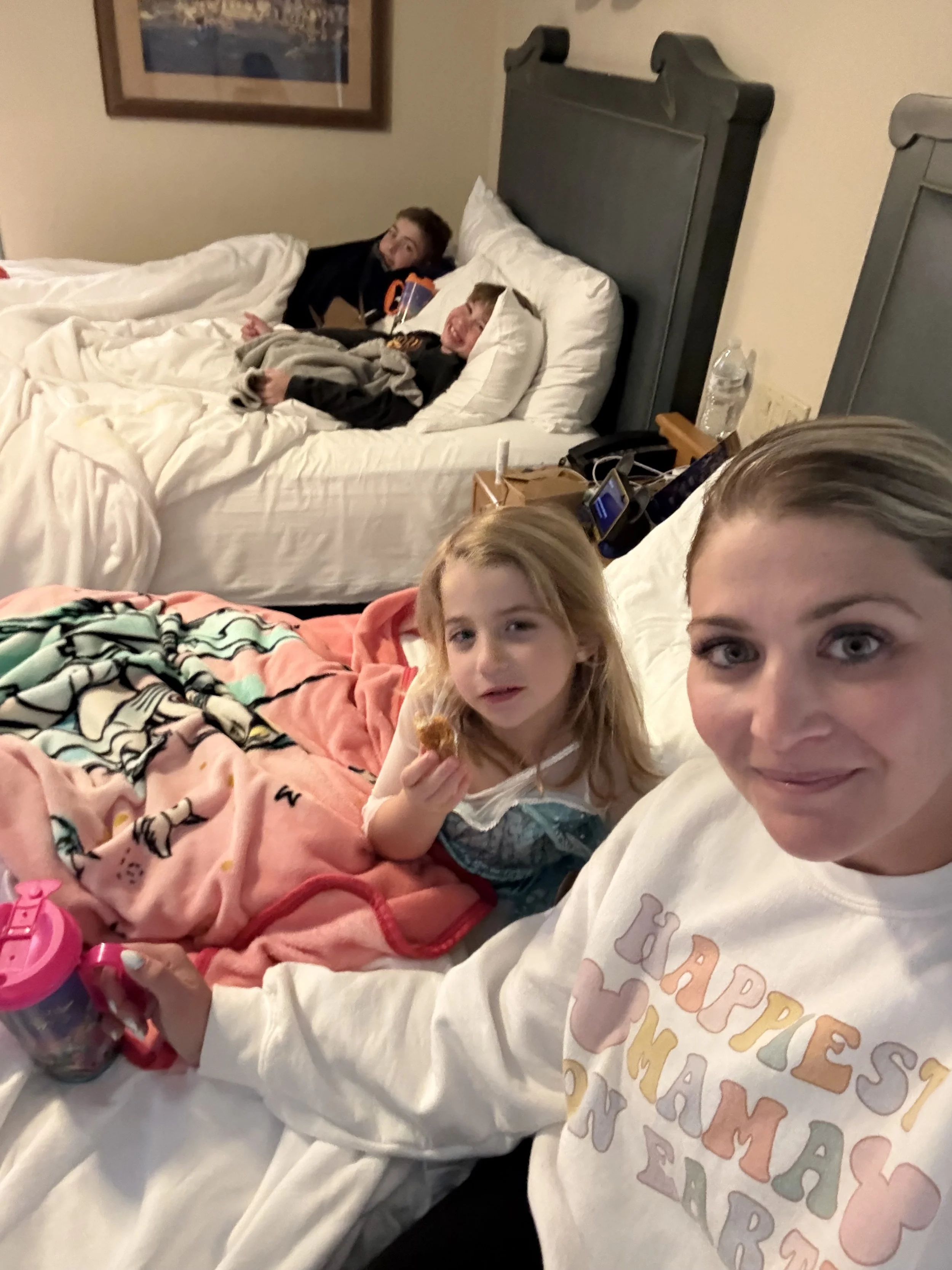 a mom and her three kids laying in two beds