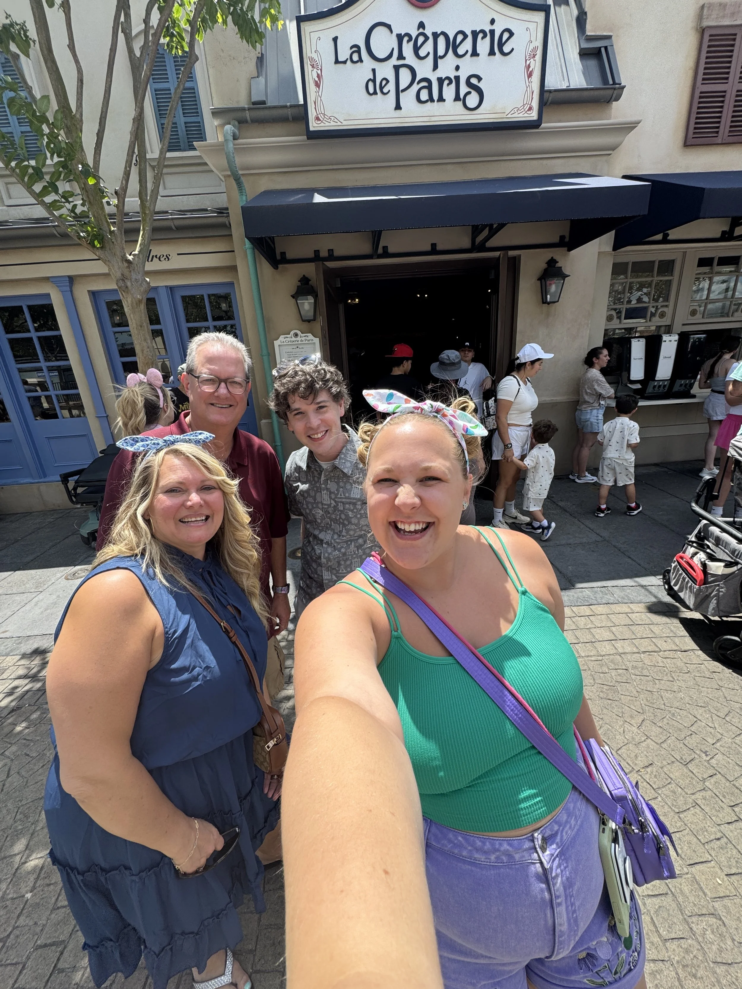 Aaron Guest celebrating with family outside La Crêperie de Paris in Epcot's France pavilion