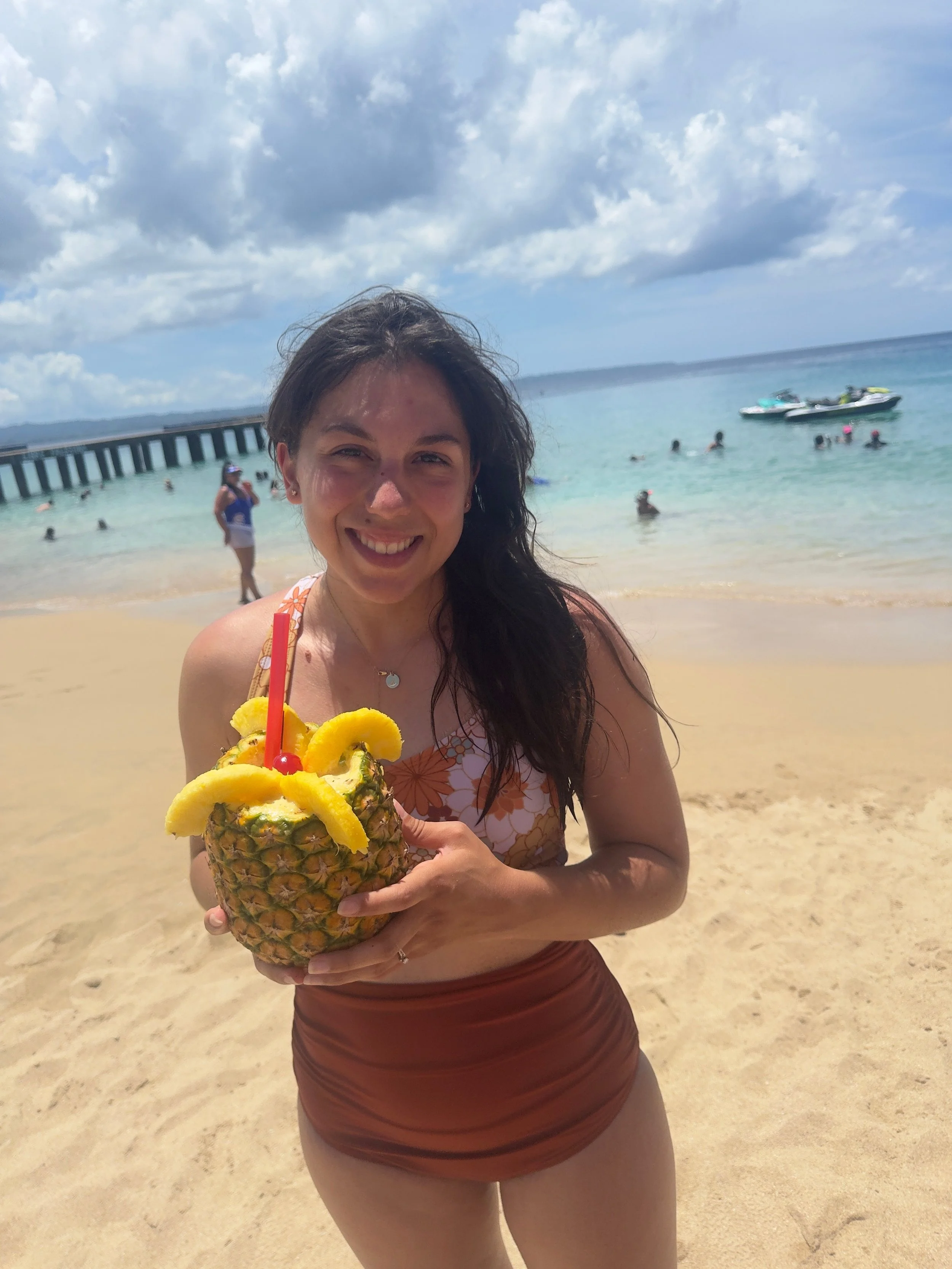 a woman standing and holding a pineapple