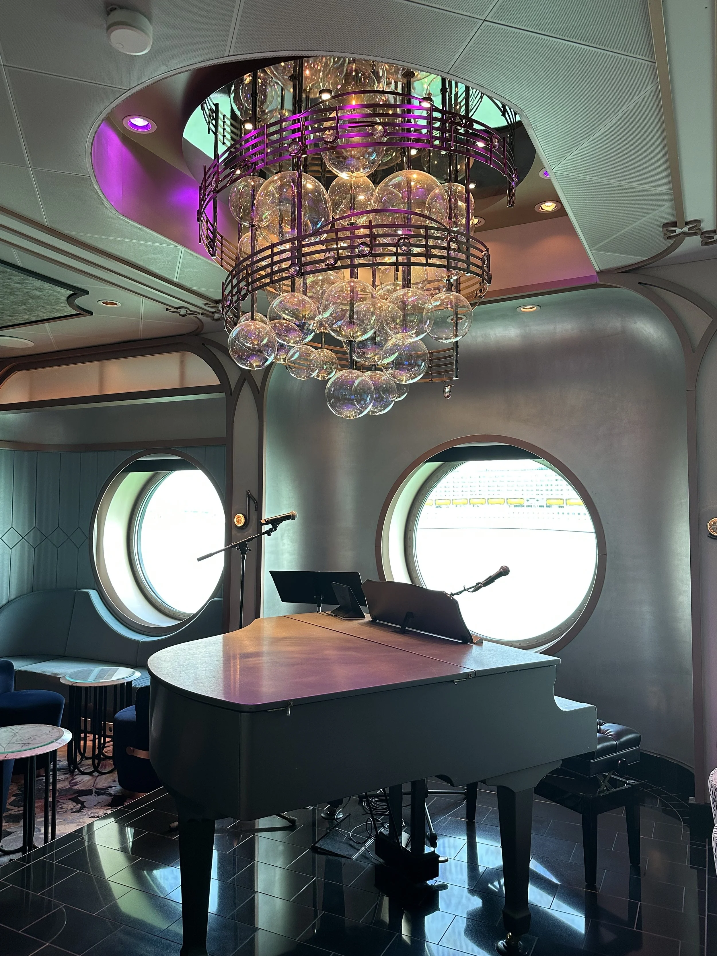 a piano with a chandelier above it