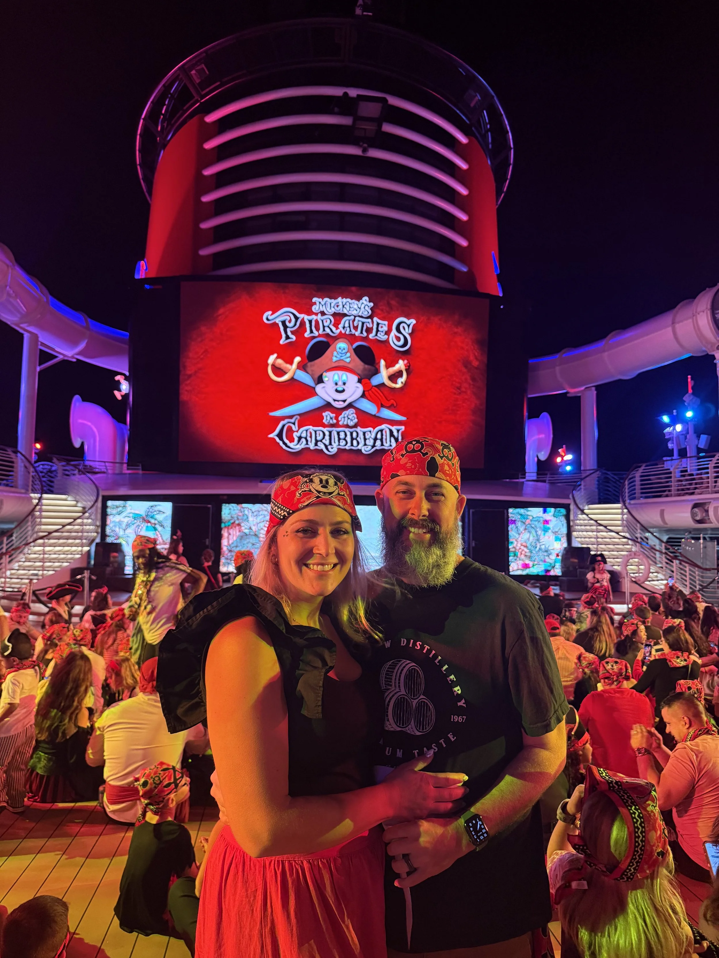 a woman and a man smiling holding each other  while wearing red banadanas