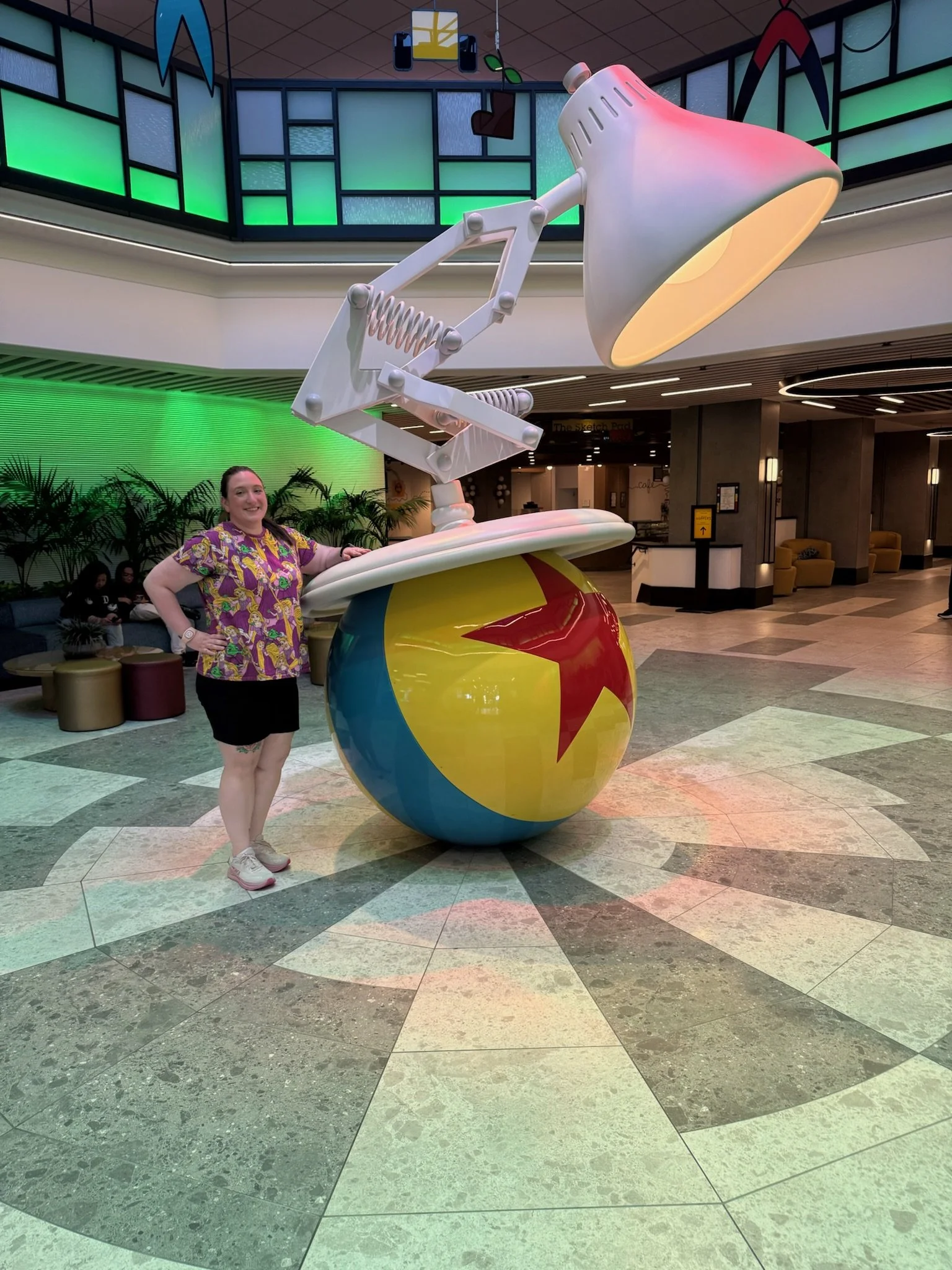 a woman standing next to a ball with a lamp on it