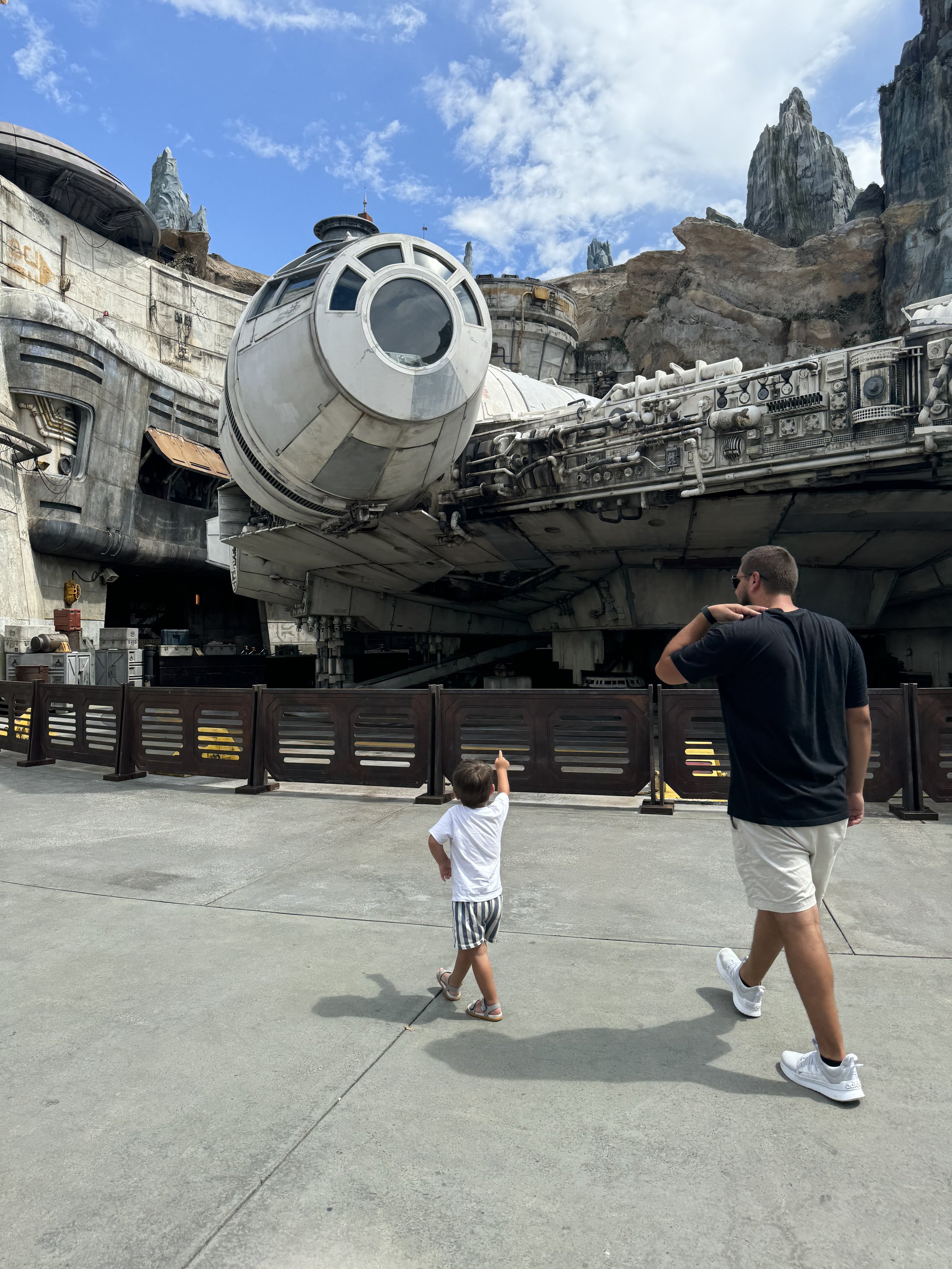 a little boy pointing at a Star Wars space ship