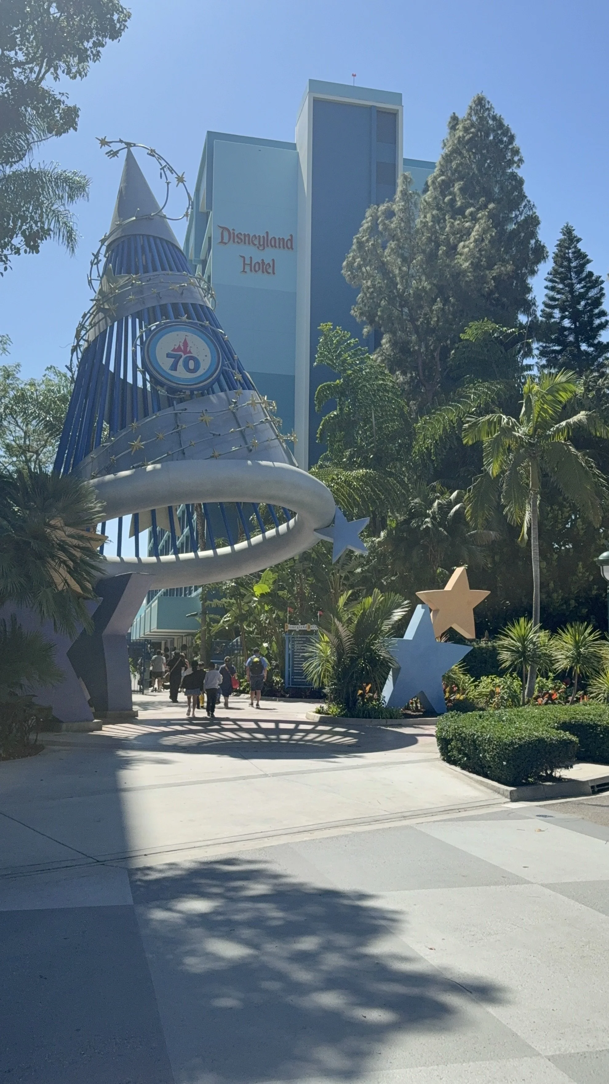 disneyland hotel with a wizards hat that has the 70th anniversary logo on it