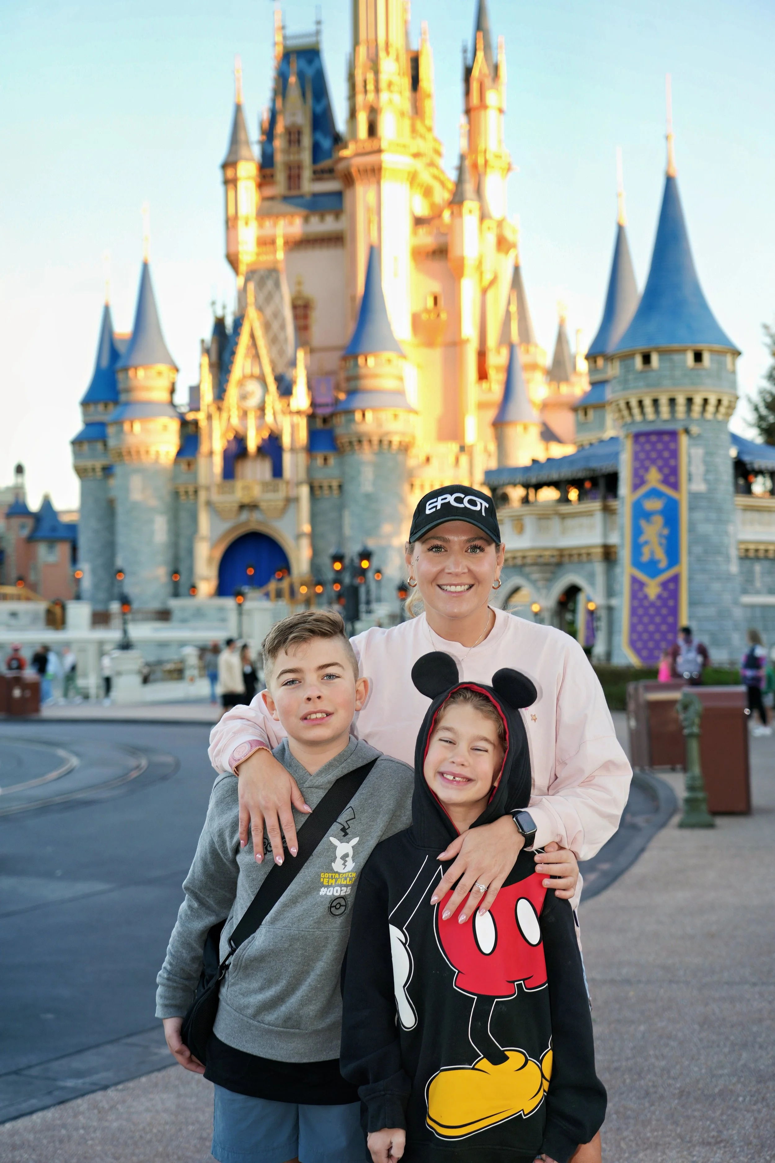 a mom and her two kids in front of the magic kingdom castle