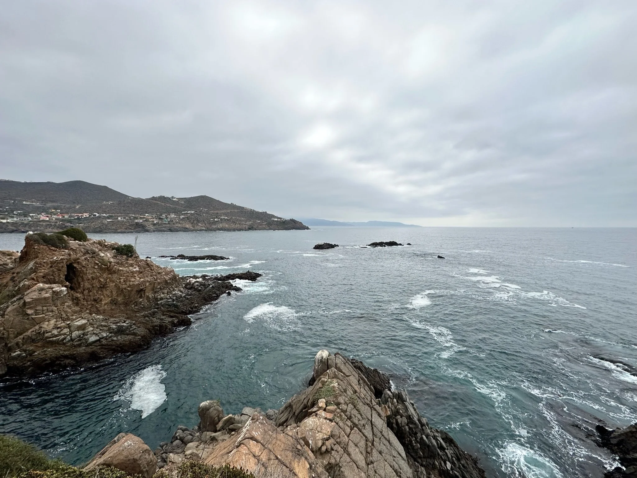 ocean waves crashing over some cliffs