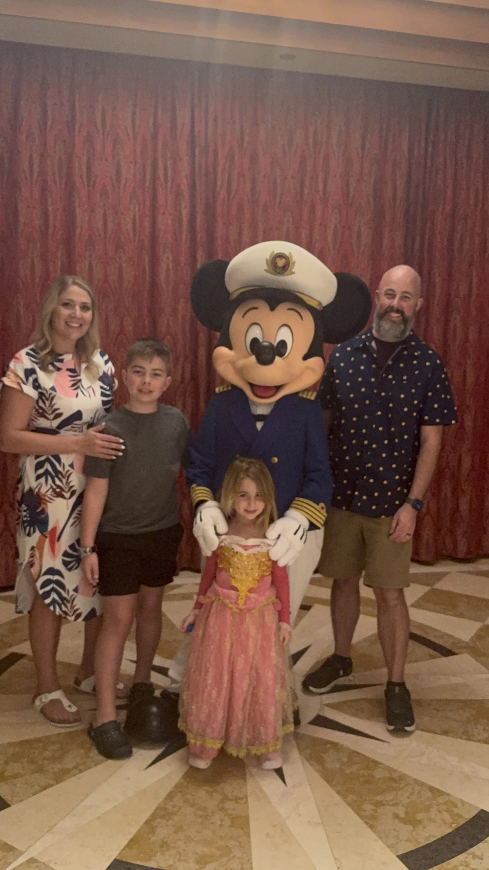 jpg Family of four posing with Captain Mickey Mouse aboard a Disney cruise, daughter dressed as a princess.