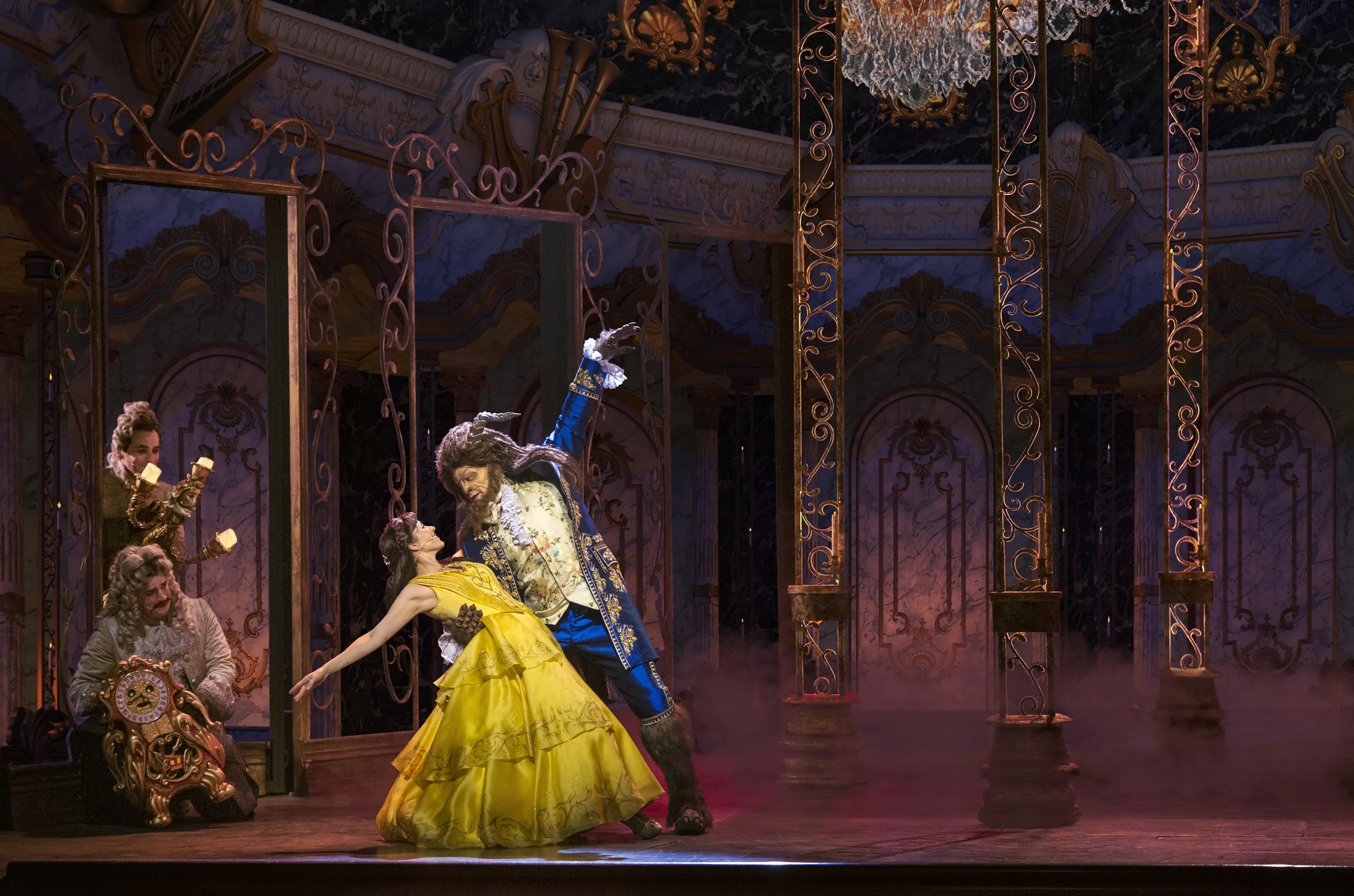 a woman in a yellow dress dancing with a man on a stage