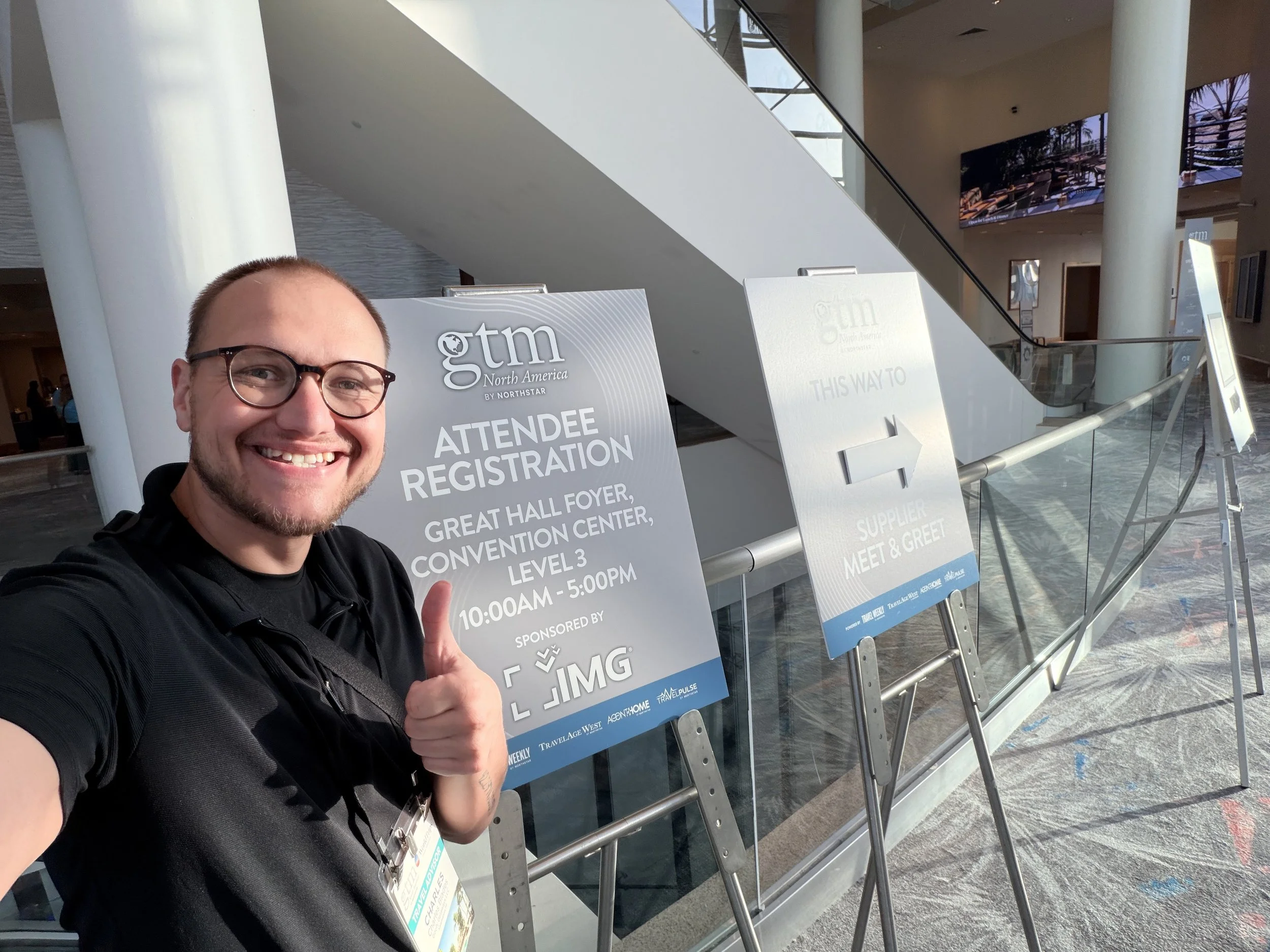 a man smiling next to signs