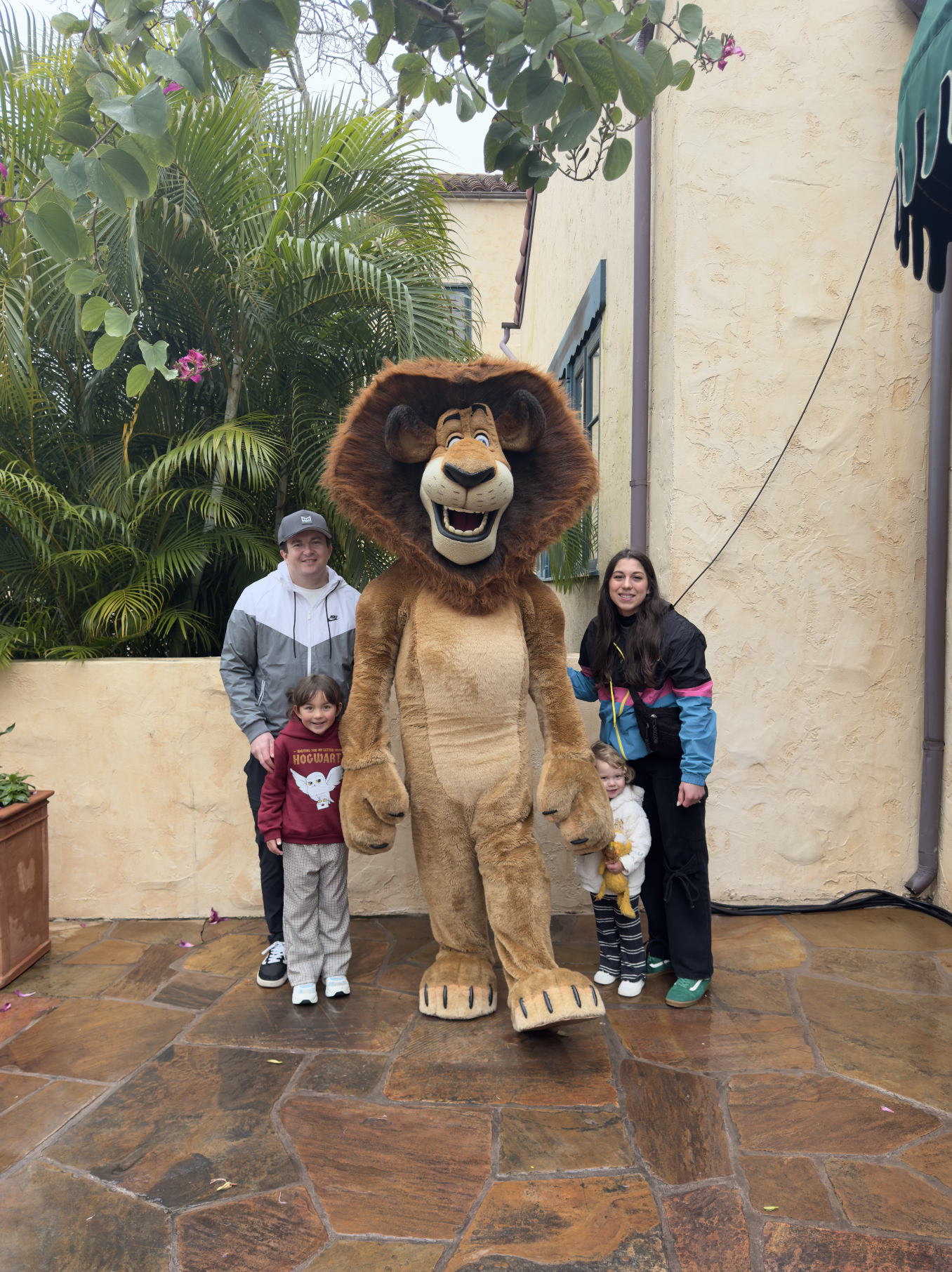 travel advisor arliss, her husband, and two small daughters posing with a lion mascot character