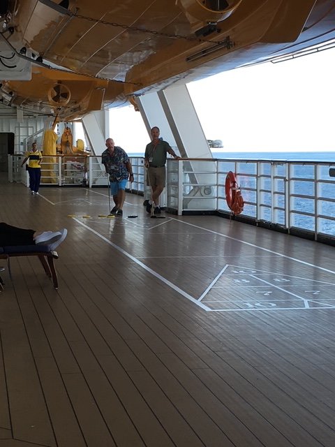 guys playing shuffle board on a disney cruise ship