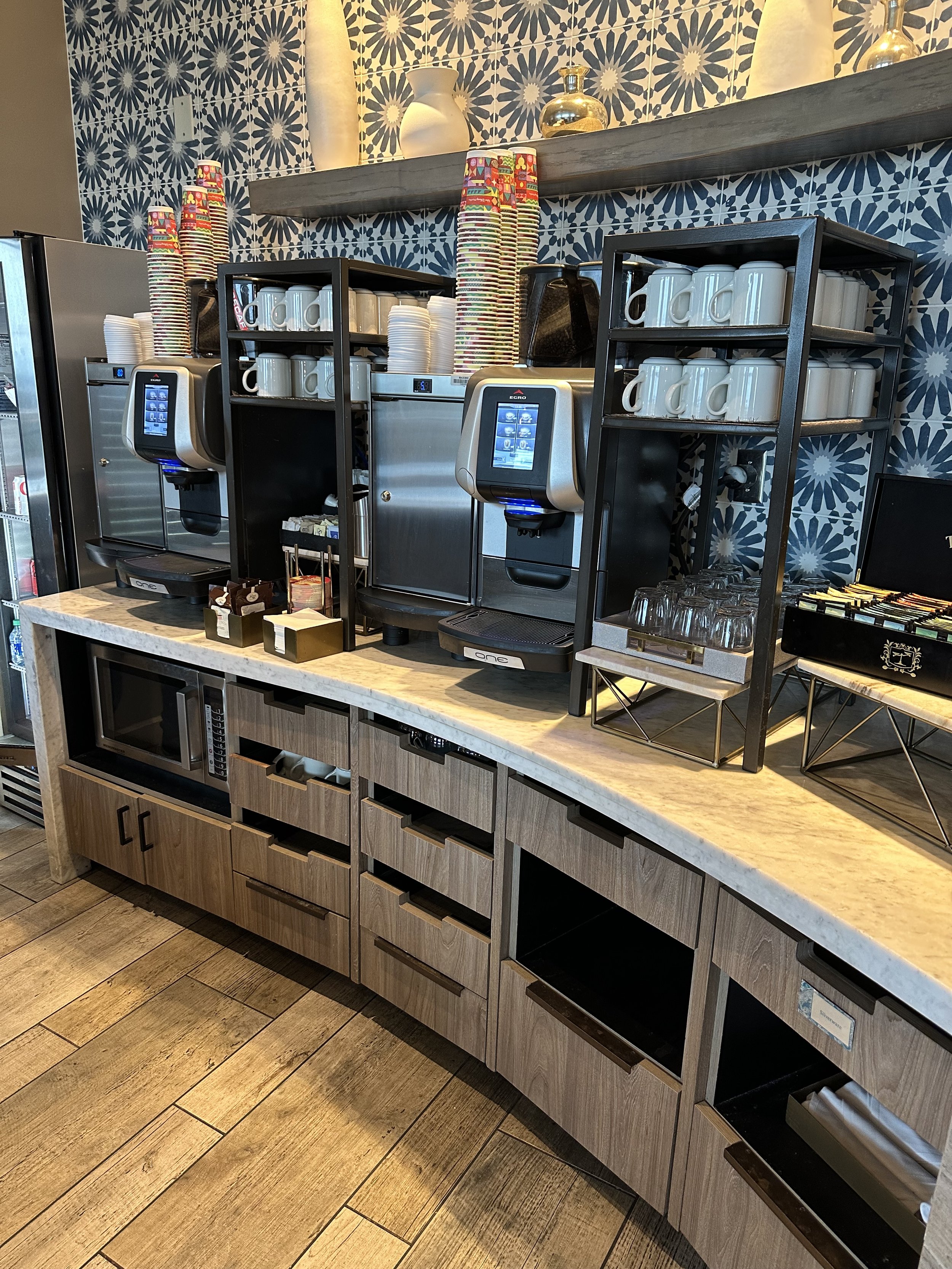A coffee and espresso station with mugs and to-go cups at a Disney Club Level lounge.
