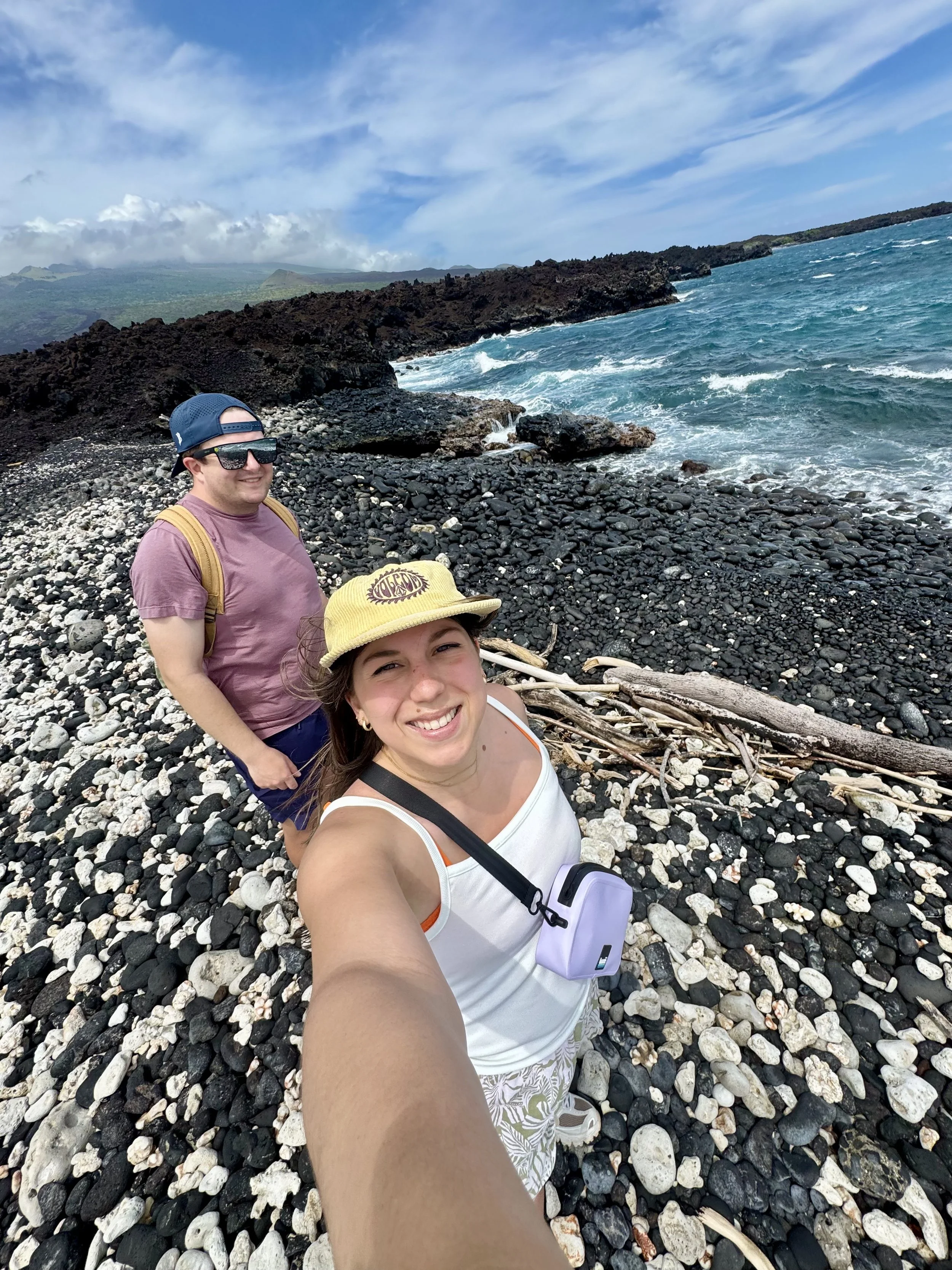 a man and woman taking a selfie on a beach