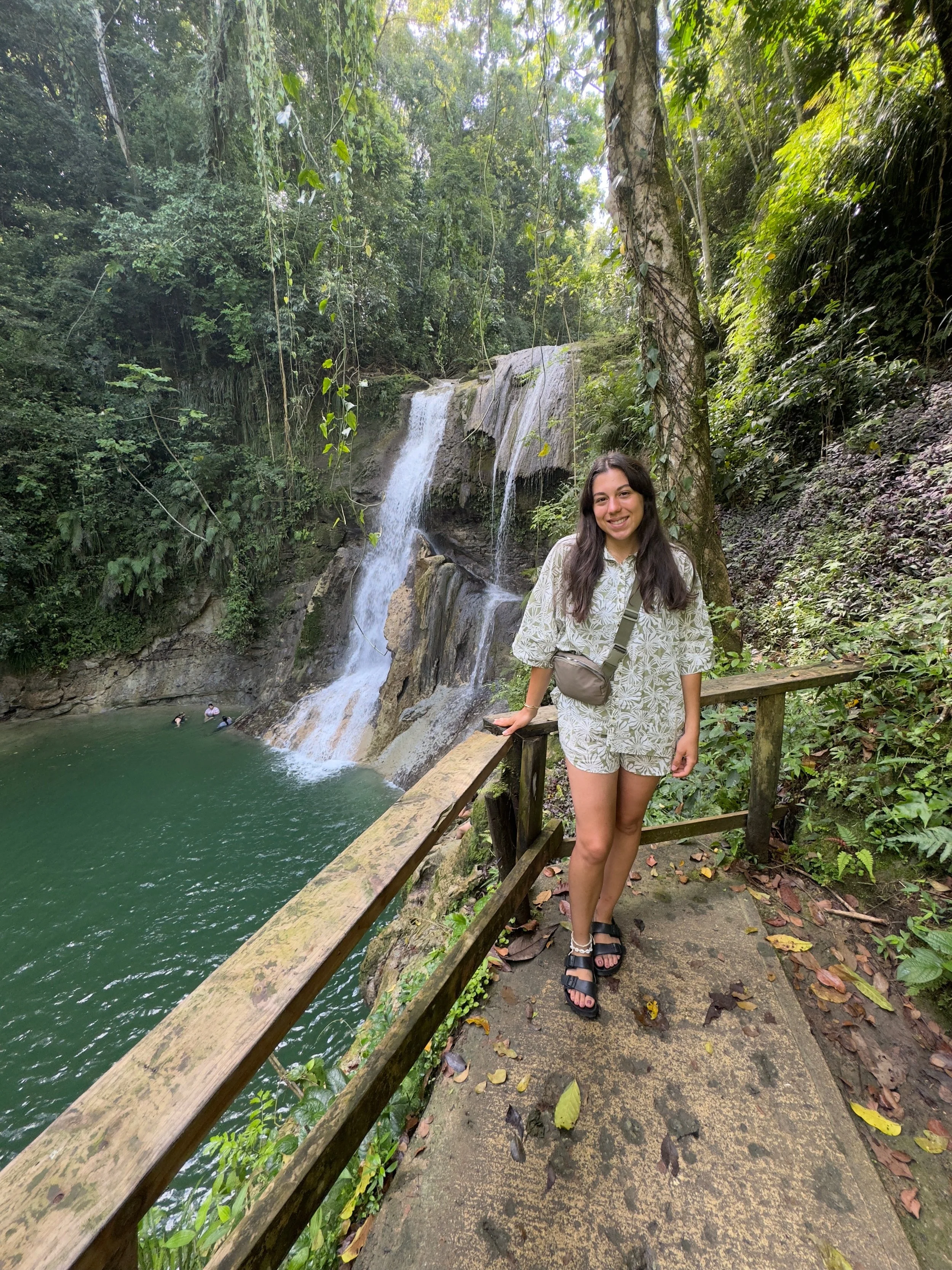 a woman standing next to a waterfall