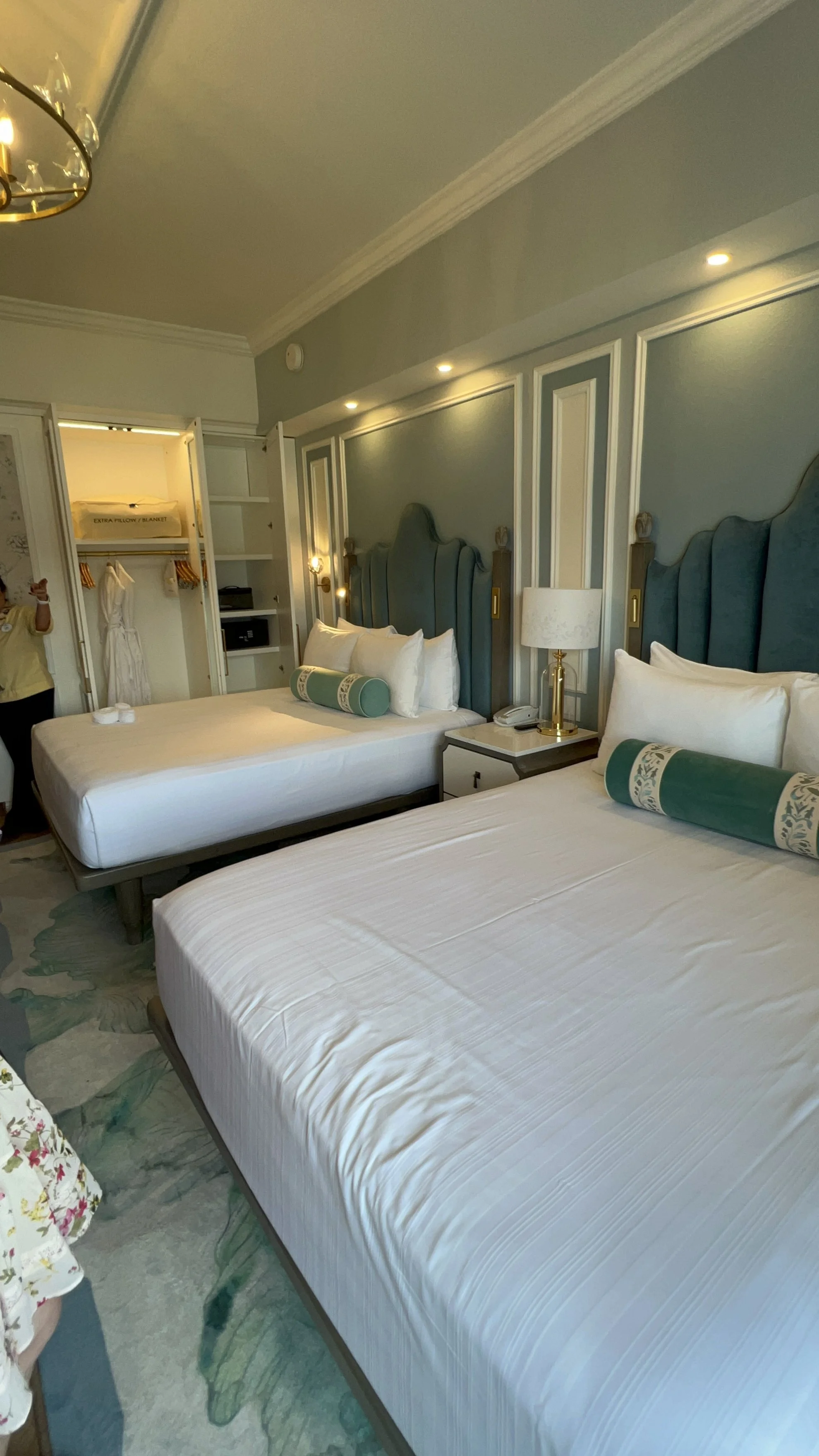 two hotel beds with blue walls and accents