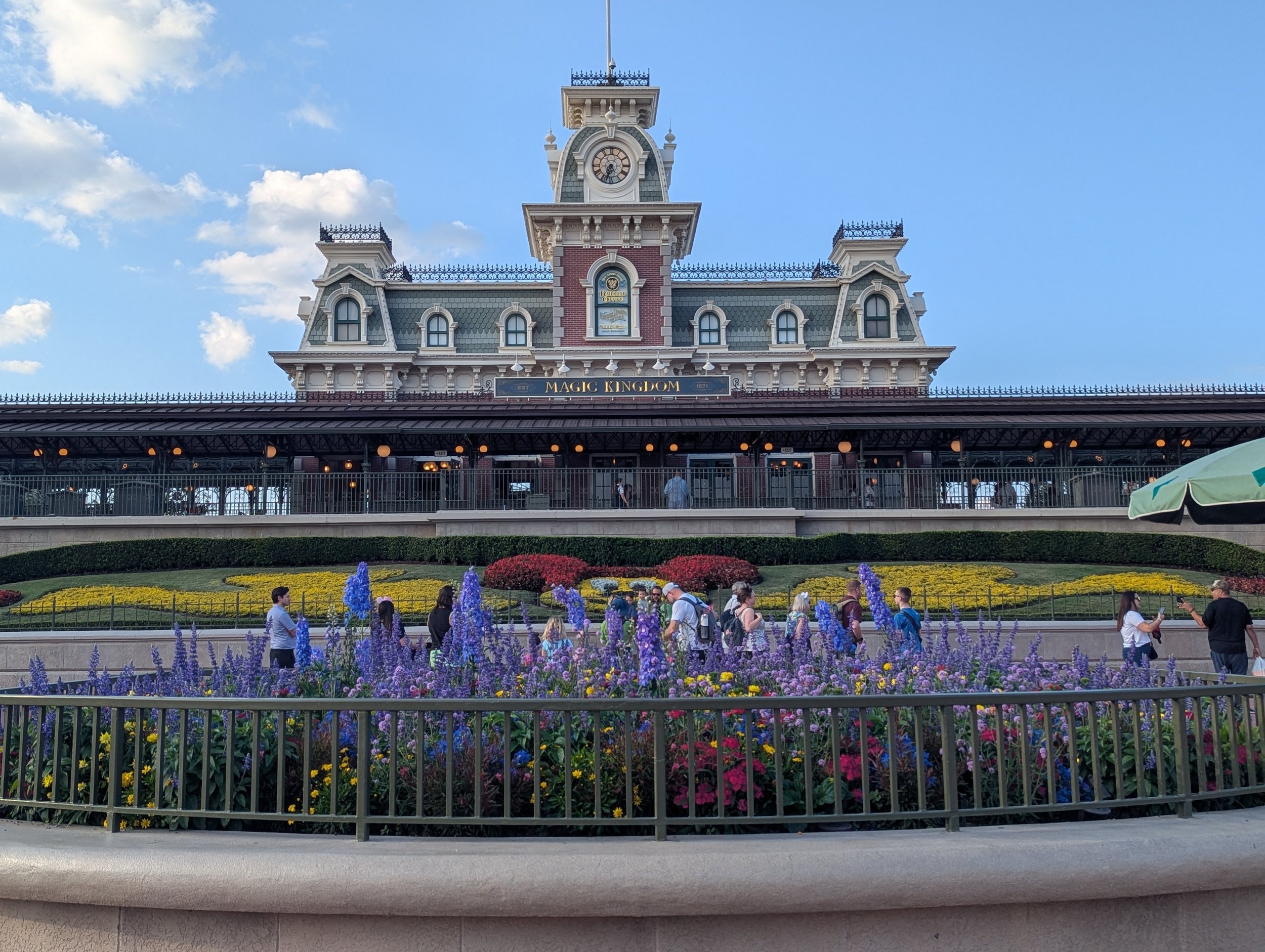 a train station with flowers in front