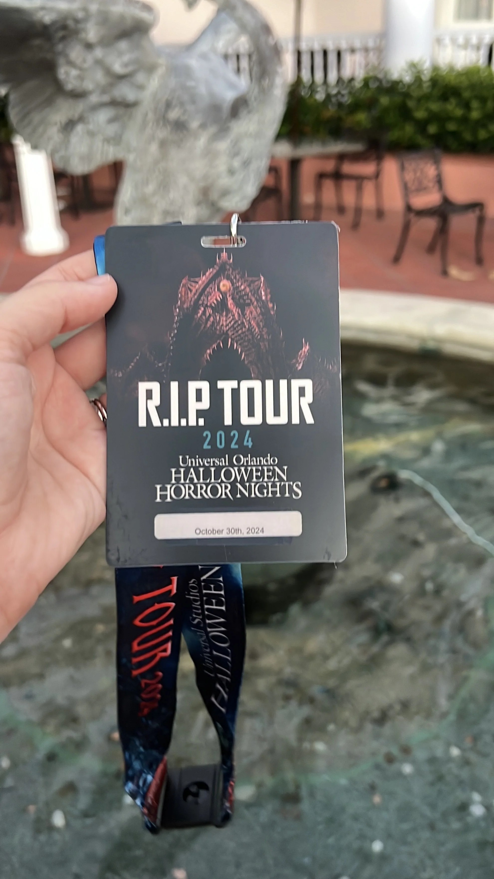 A hand holding a Universal Orlando Halloween Horror Nights "R.I.P. Tour 2024" VIP lanyard and wristband, dated October 30th, 2024.