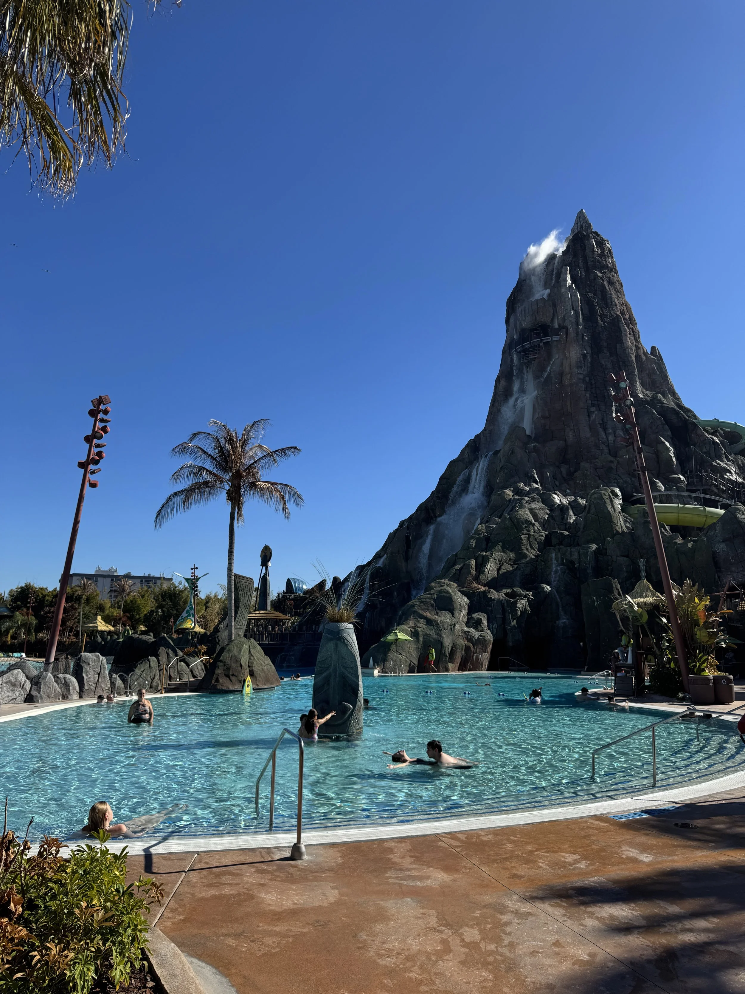 a pool with a fake full size volcano behind it