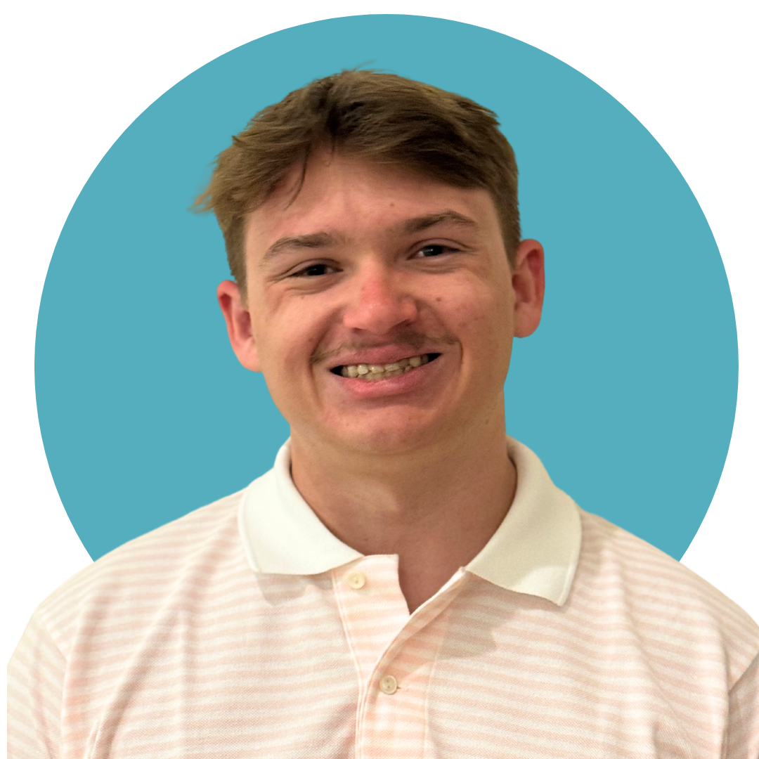 a man with short brown hair wearing a pink stripped collared shirt 