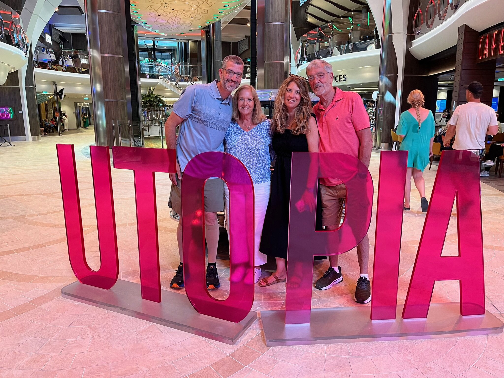 4 people standing in front of a red sign that says utopia