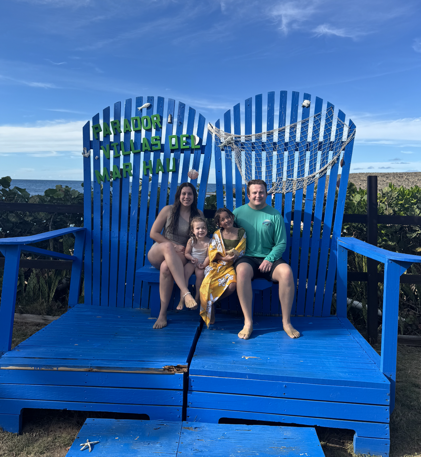 travel advisor arliss, her husband, and two small daughters on an oversized blue beach chair