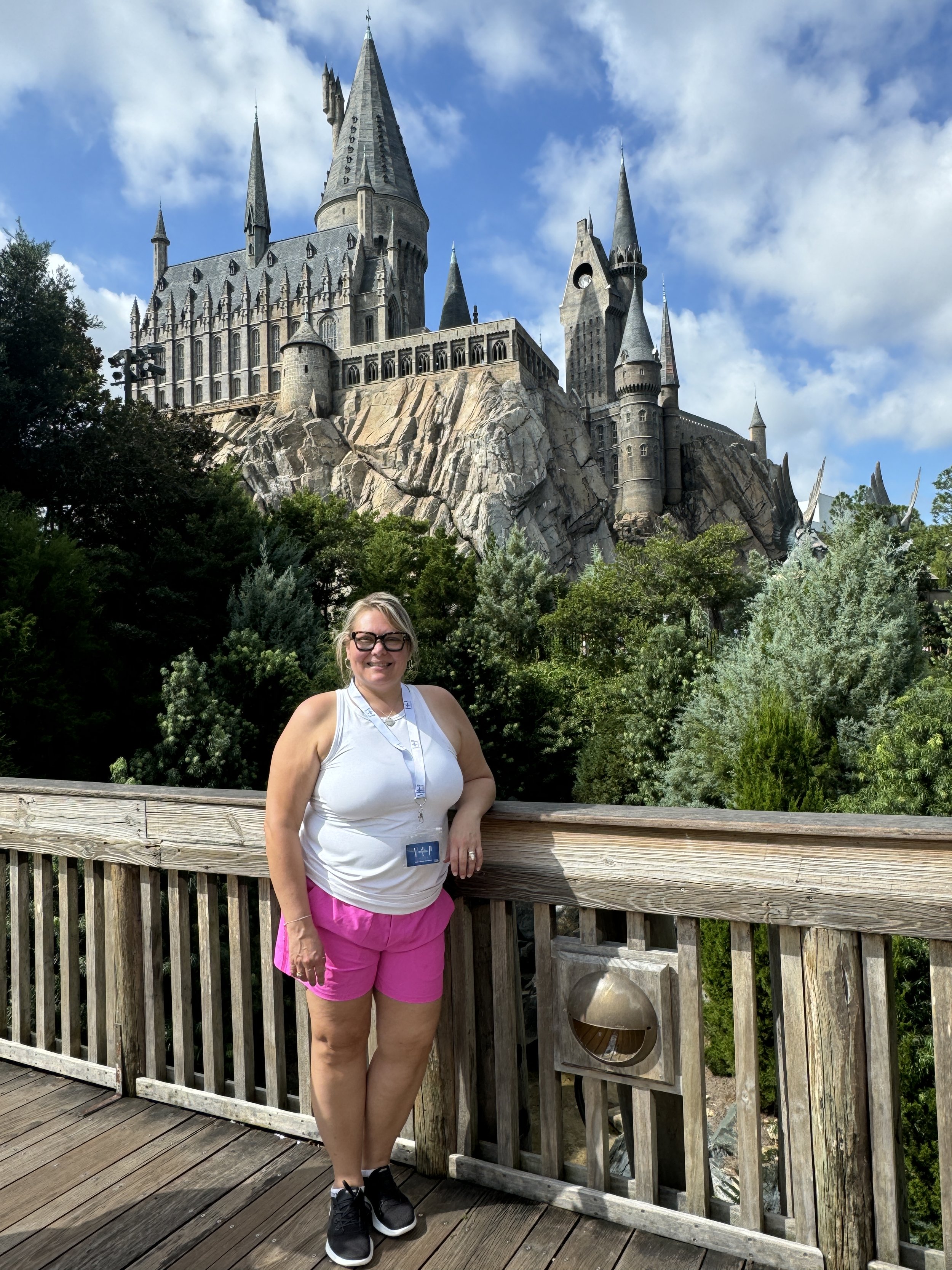 a woman smiling in front of the Harry Potter castle
