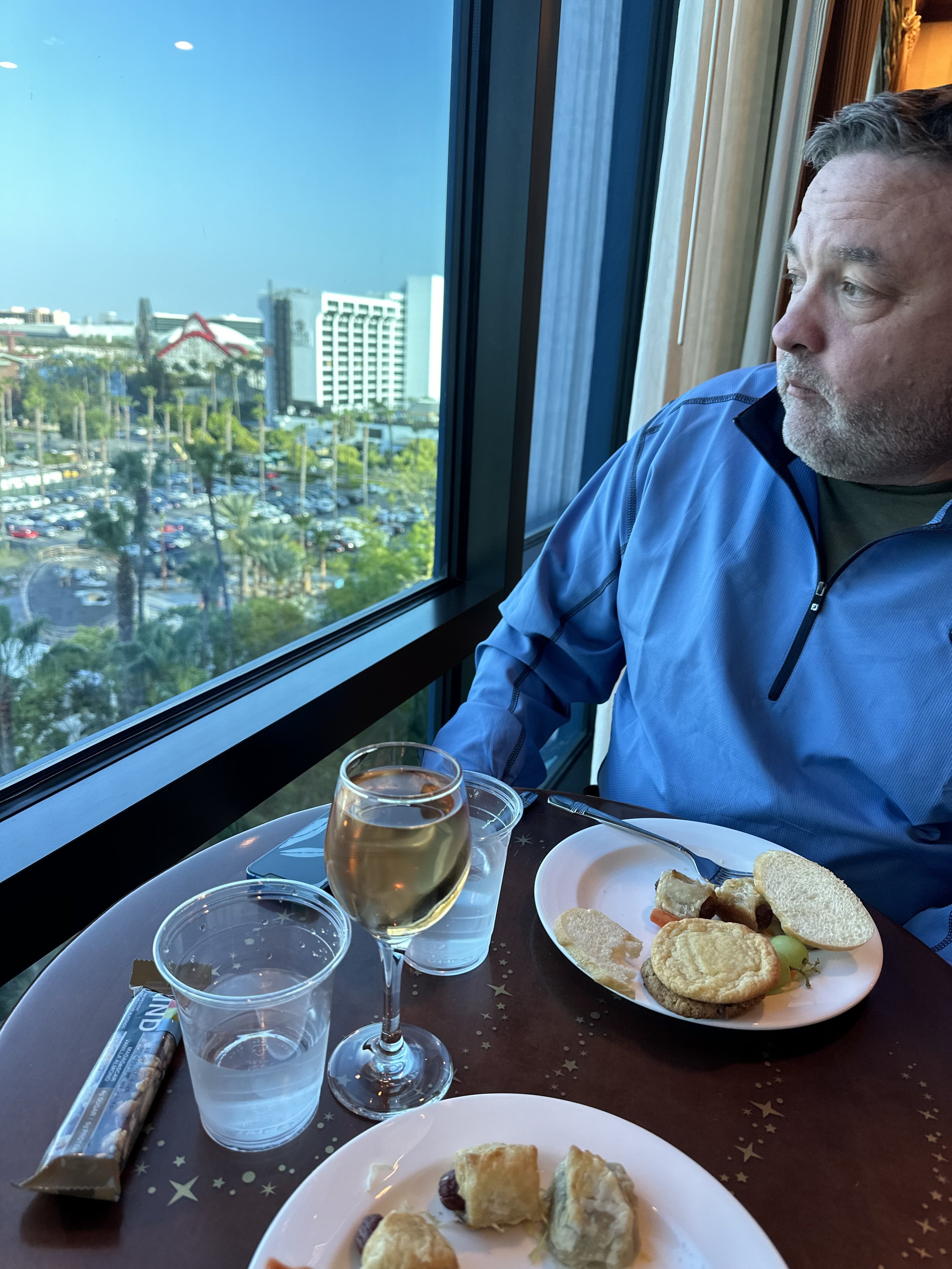 A guest enjoys evening appetizers and a glass of wine with a resort view from a Club Level lounge.
