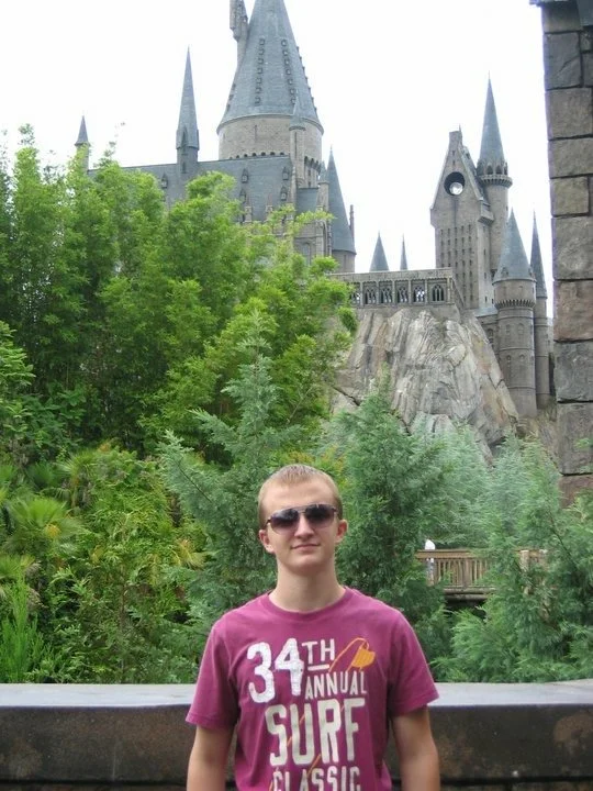 A young traveler standing in front of Hogwarts castle at Universal's Wizarding World of Harry Potter.