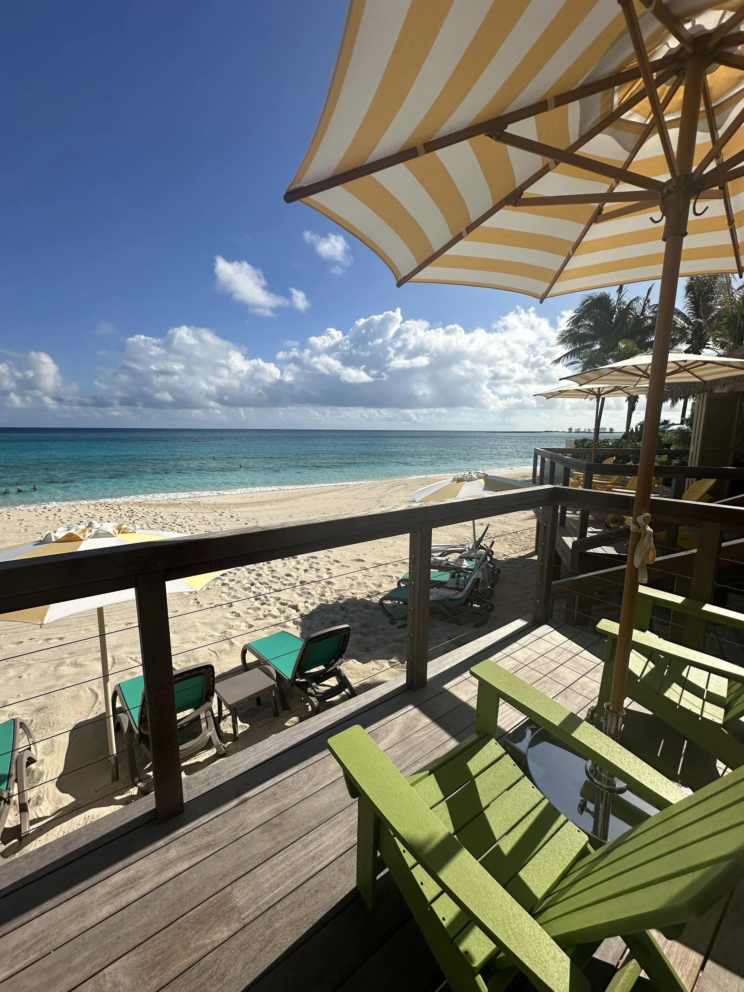 : Empty beach loungers and an umbrella on a quiet stretch of sand at Royal Beach Club Paradise Island.