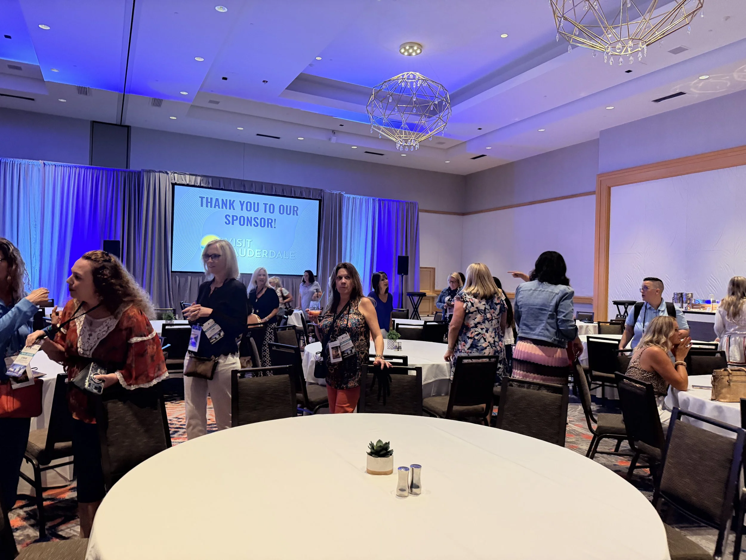 a business room full of tables and people walking around