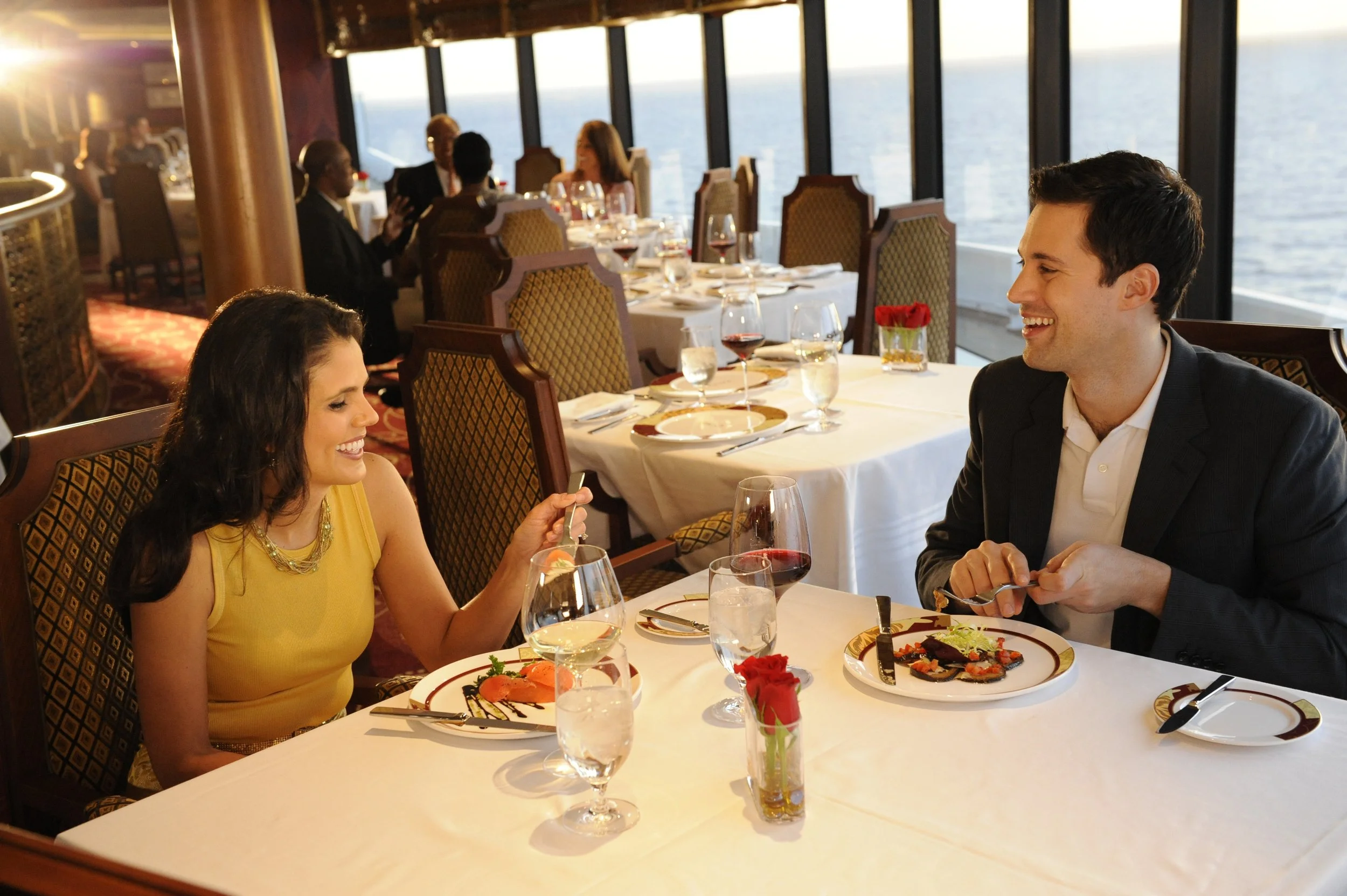 a man and woman sitting at a table smiling