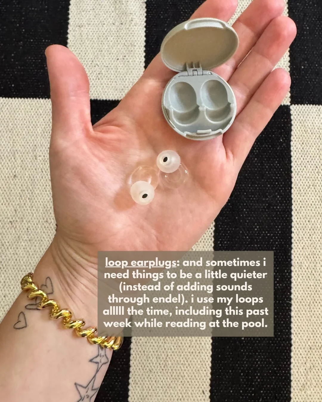 Hand holding a pair of Loop earplugs and their case