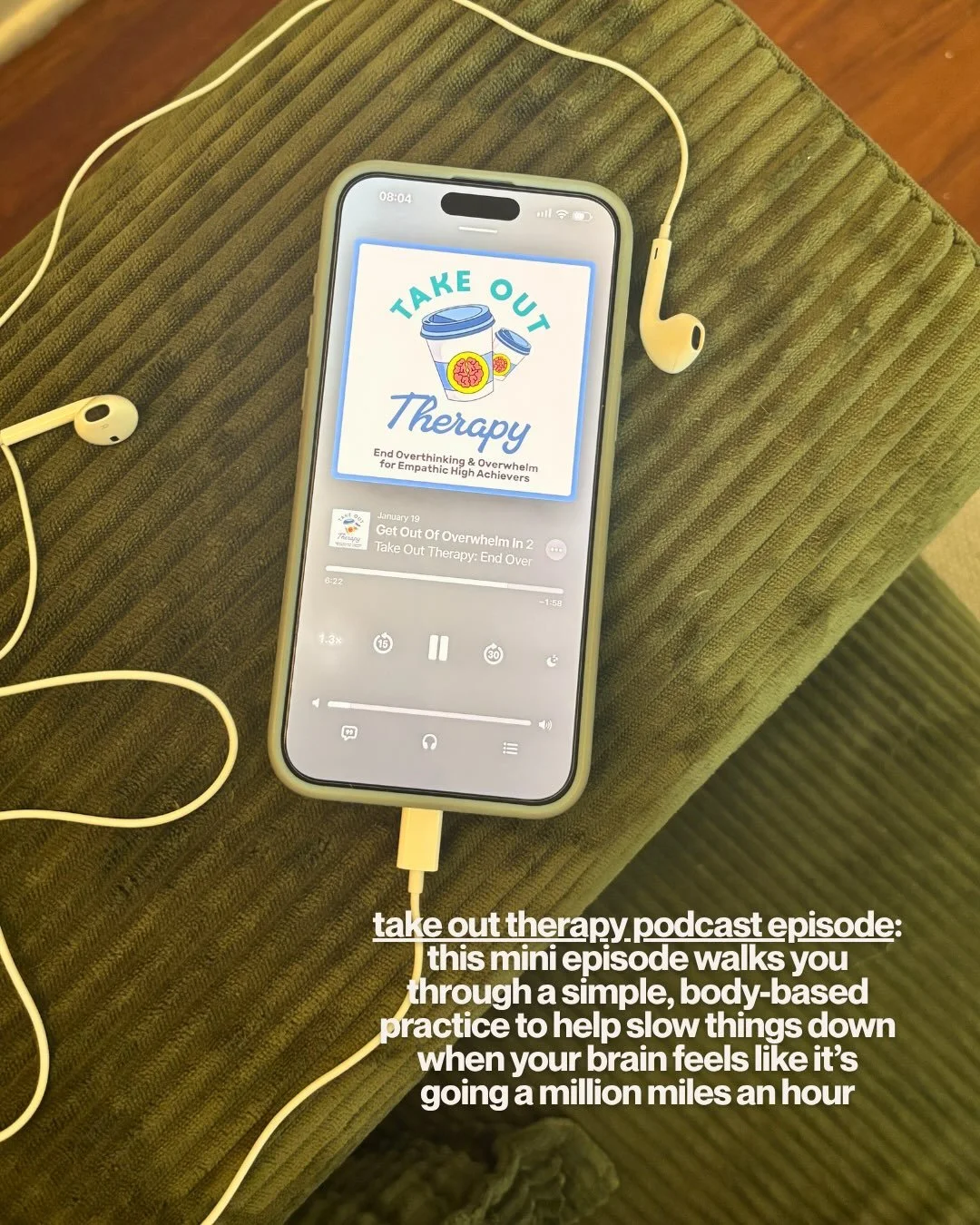 Phone with earbuds playing an episode of the Take Out Therapy podcast