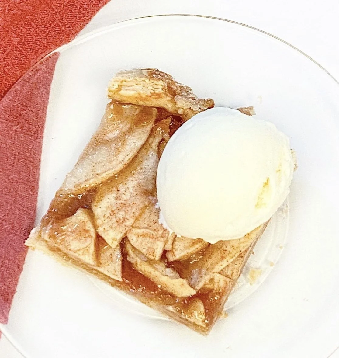 A slice of delicious fall apple tart with ice cream.