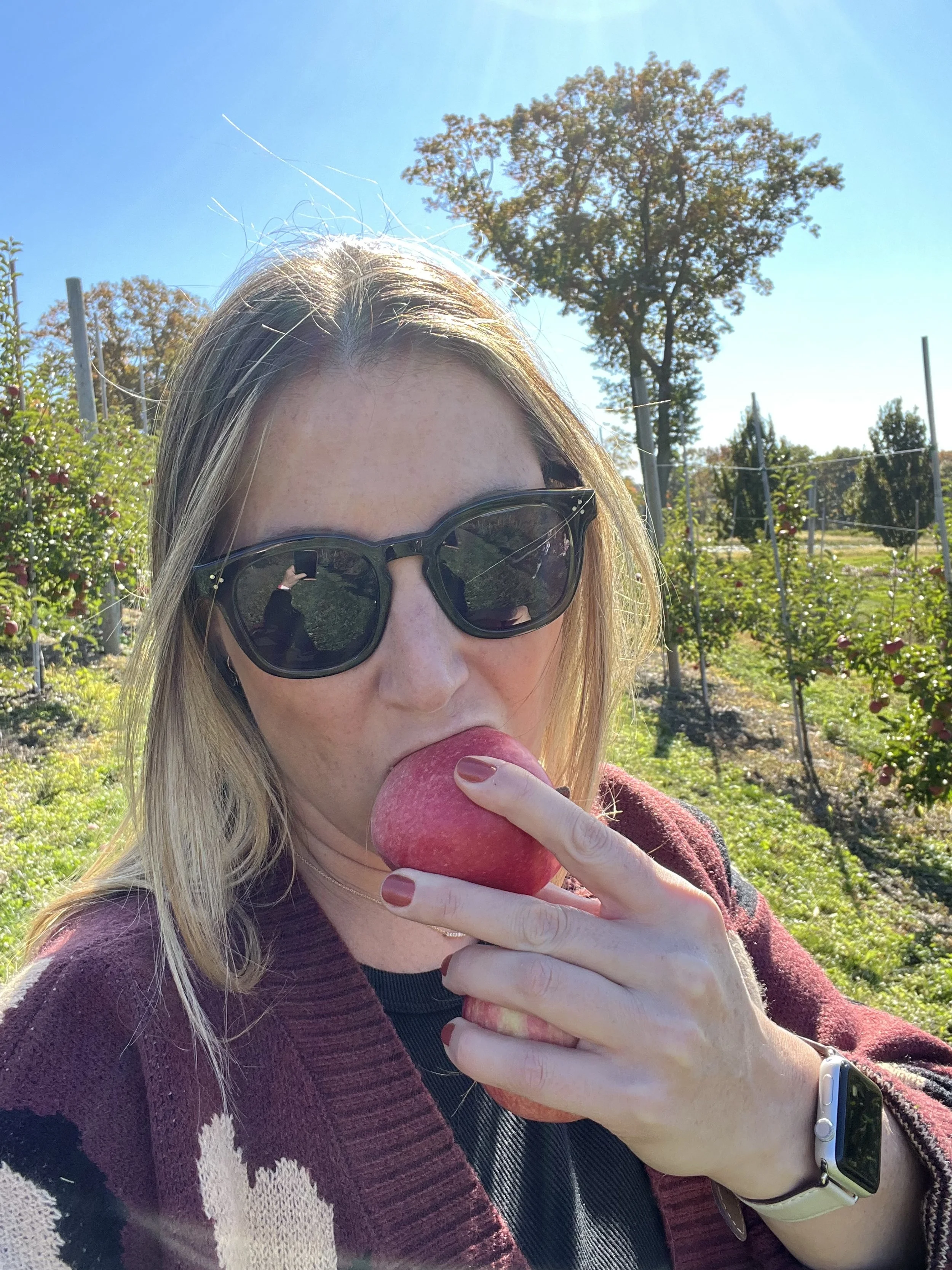 Elia taking a bite out of an apple during fall apple picking