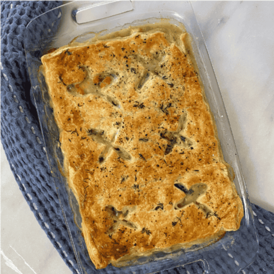A glass baking dish of freshly made chicken pot pie.