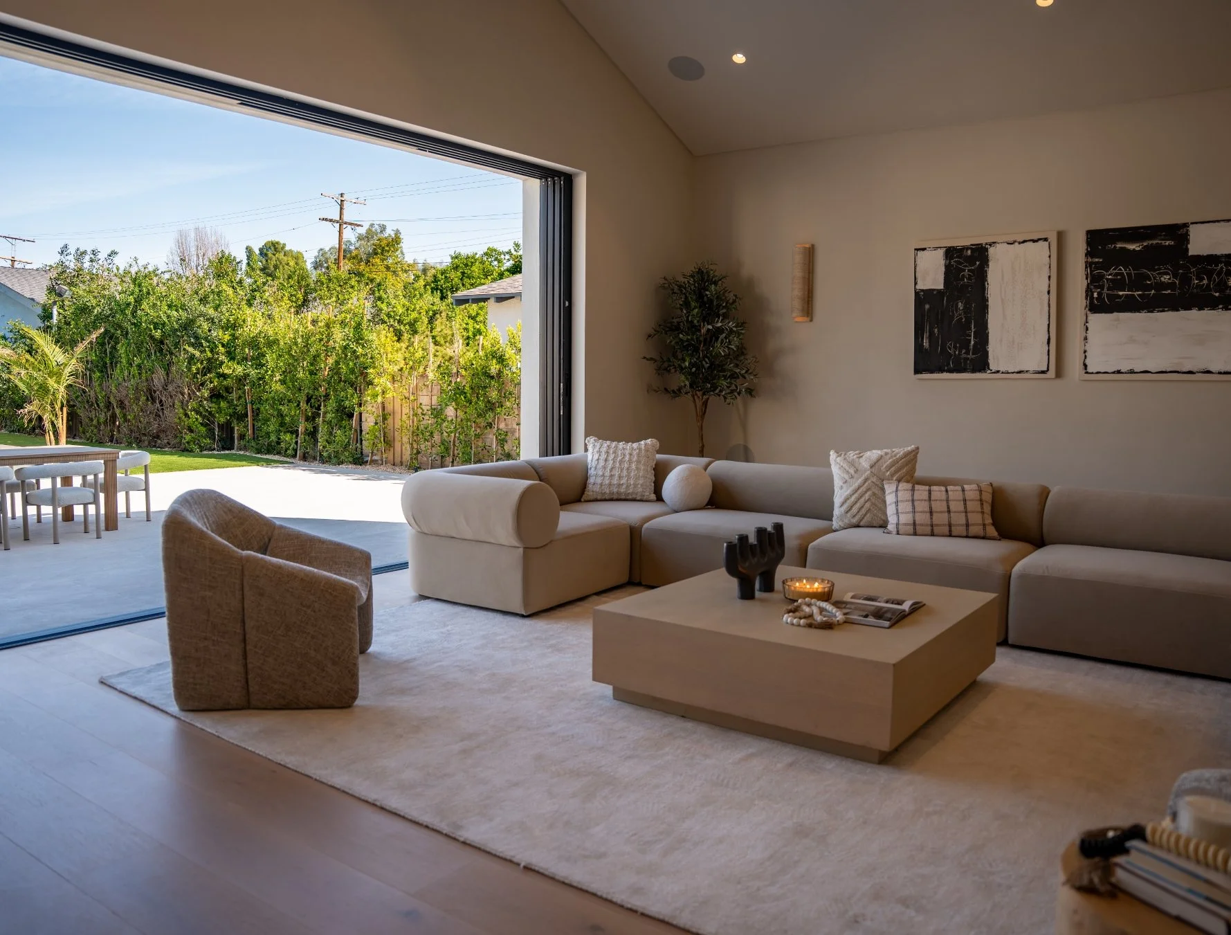 Modern two-story house with a white exterior and black roof, featuring multiple windows, a black garage door, and a white car parked in front.