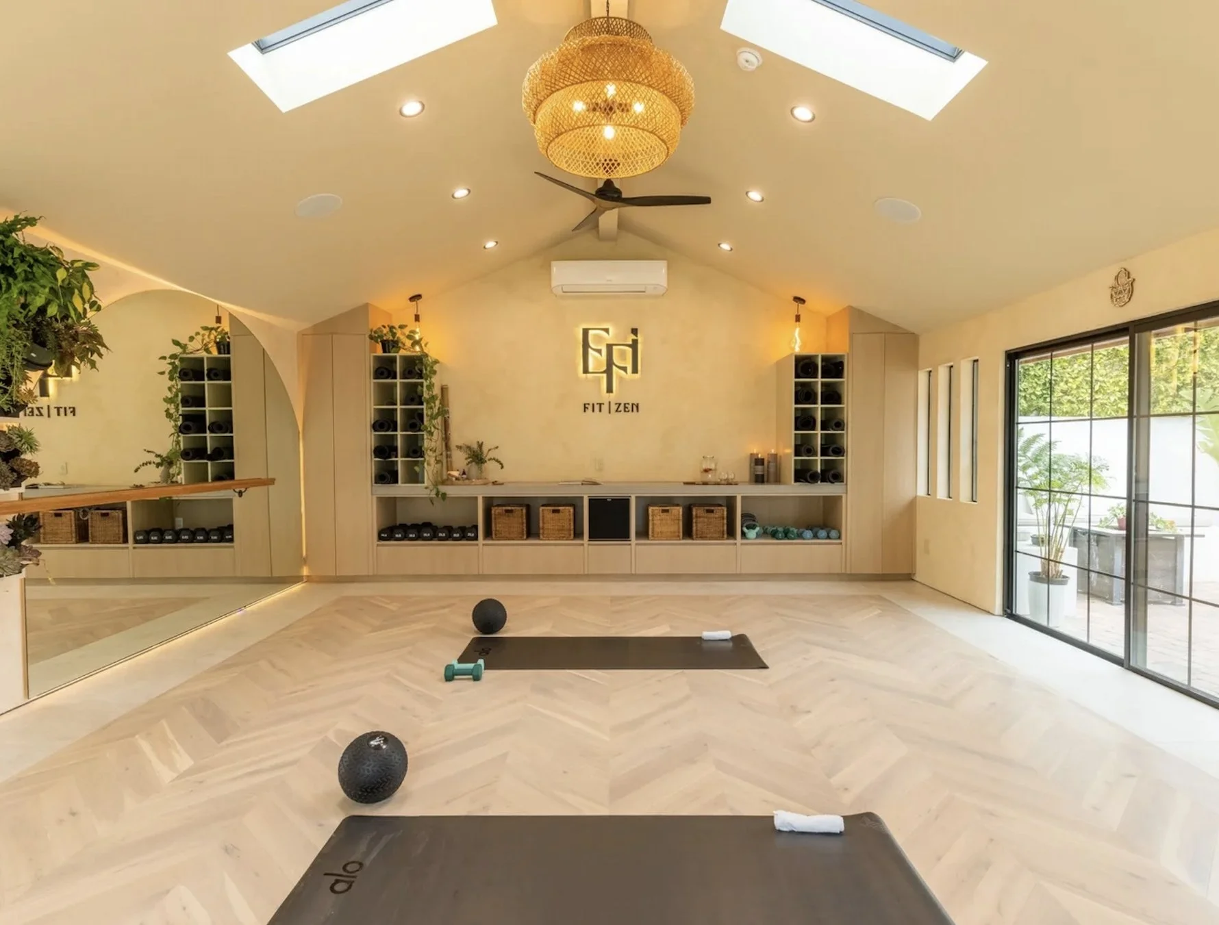Interior of a modern tea shop with shelves of tea boxes, a central island with tea products, and seating areas with bar stools. Wooden accents and potted plants are visible.