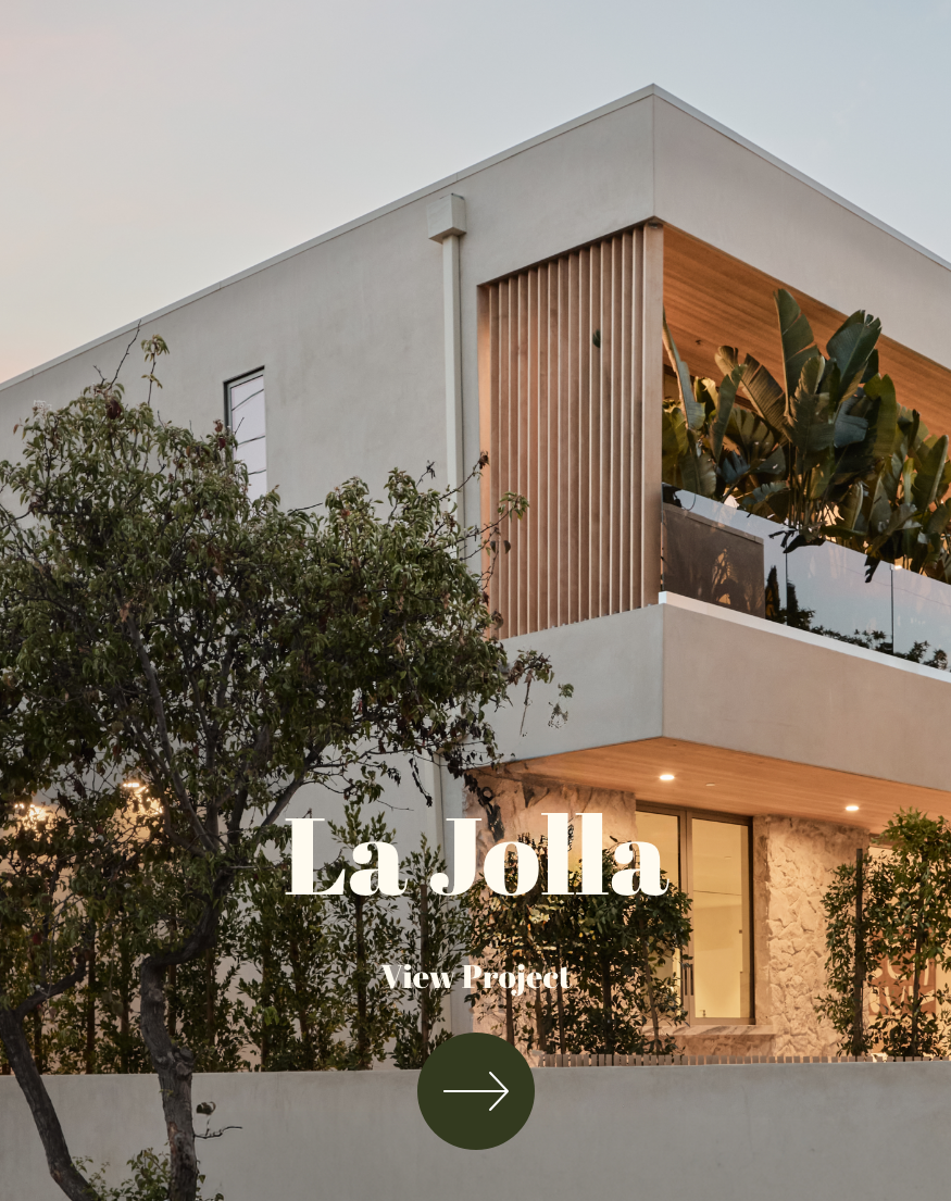 Modern multi-story house with white exterior, wooden accents, and a balcony with plants, viewed during sunset with trees in the foreground.