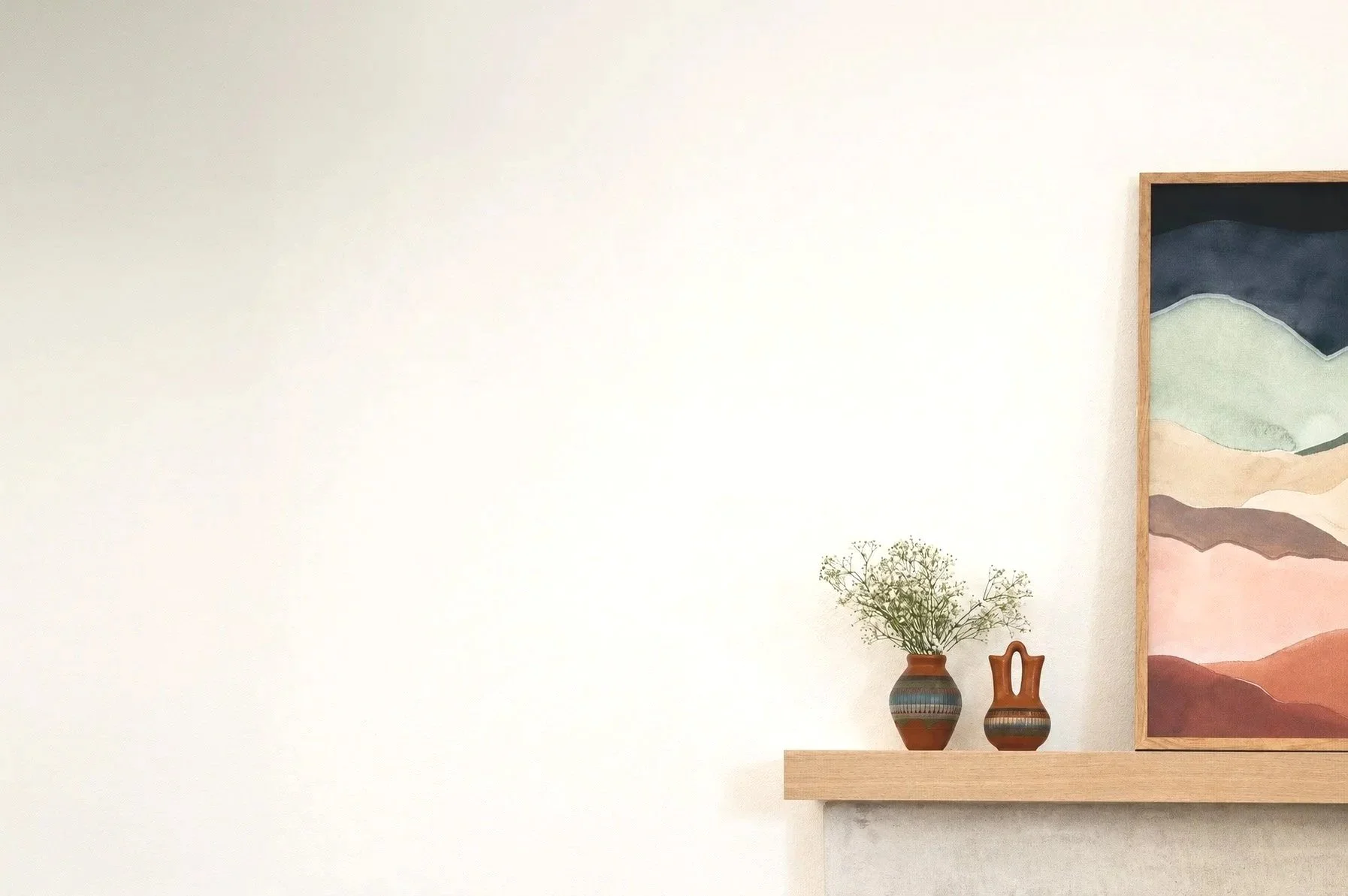 Interior wall decor with a colorful landscape painting framed in wood, a small vase with green foliage, and a decorative ceramic piece on a wooden shelf.