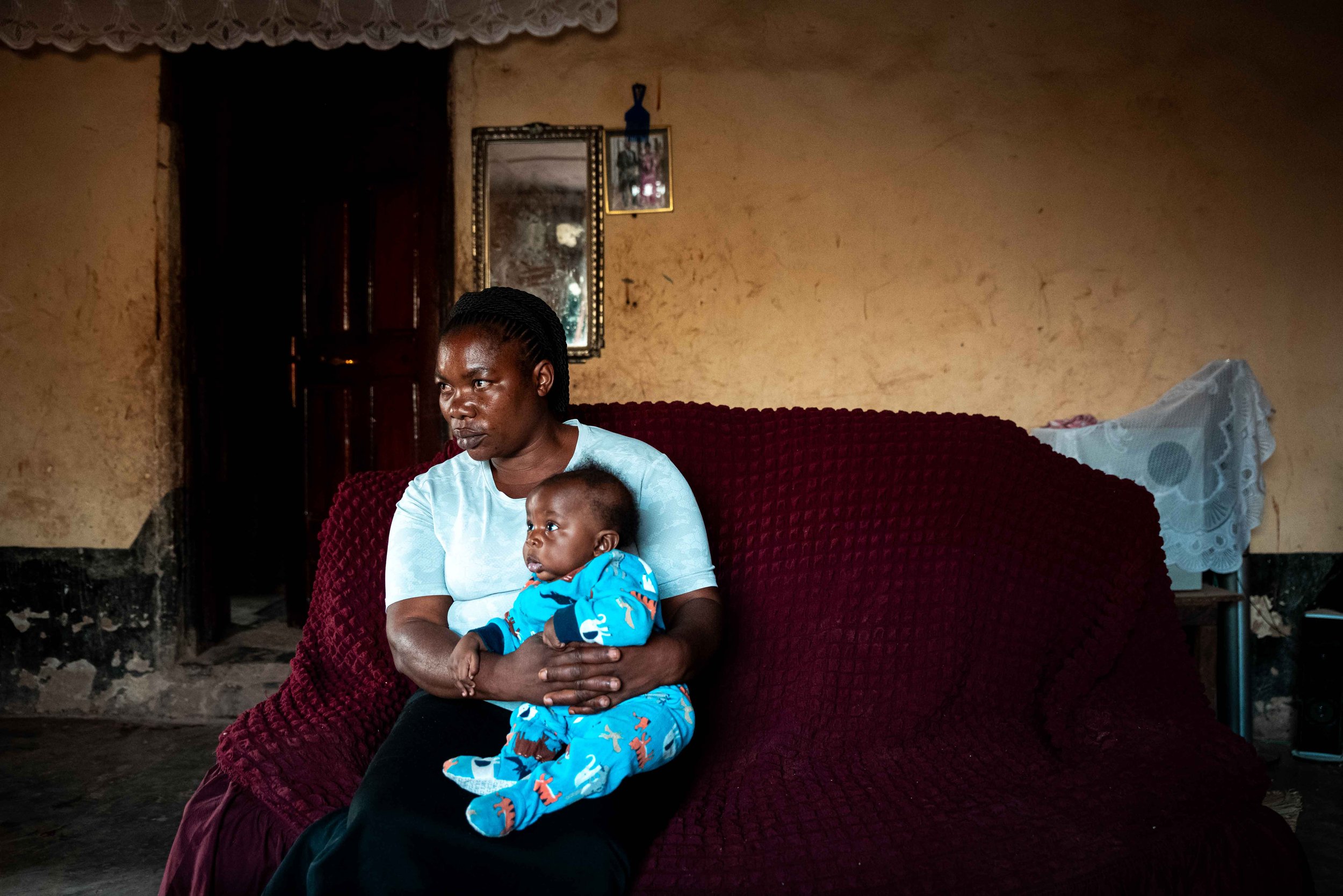 Portrait of Sifa Manegabé, 35, holding her newborn baby. She says she lived in fear of another birth defect during her pregnancy. Fungurume, Lualaba Province, Democratic Republic of the Congo.