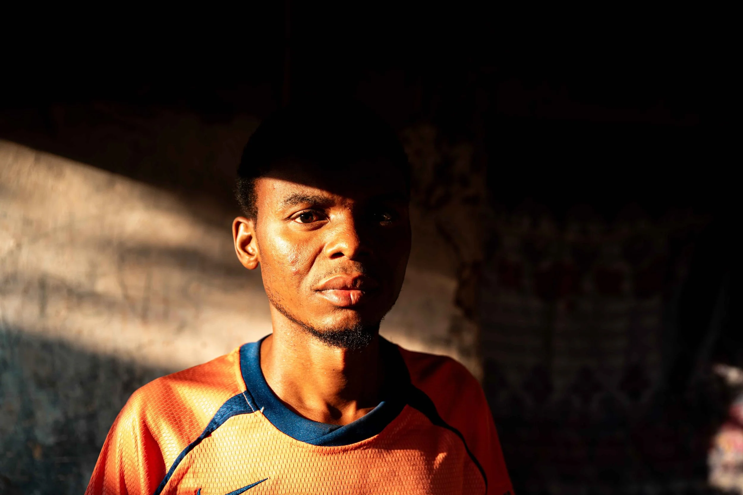 Portrait of Komba Makessa Denis, 27, suffering from itching, skin rashes, and bleeding, which he attributes to emissions from Tenke Fungurume Mining’s smelter plant in Kabombwa. Lacking medical assistance, he self-medicates at home. Lualaba Province,