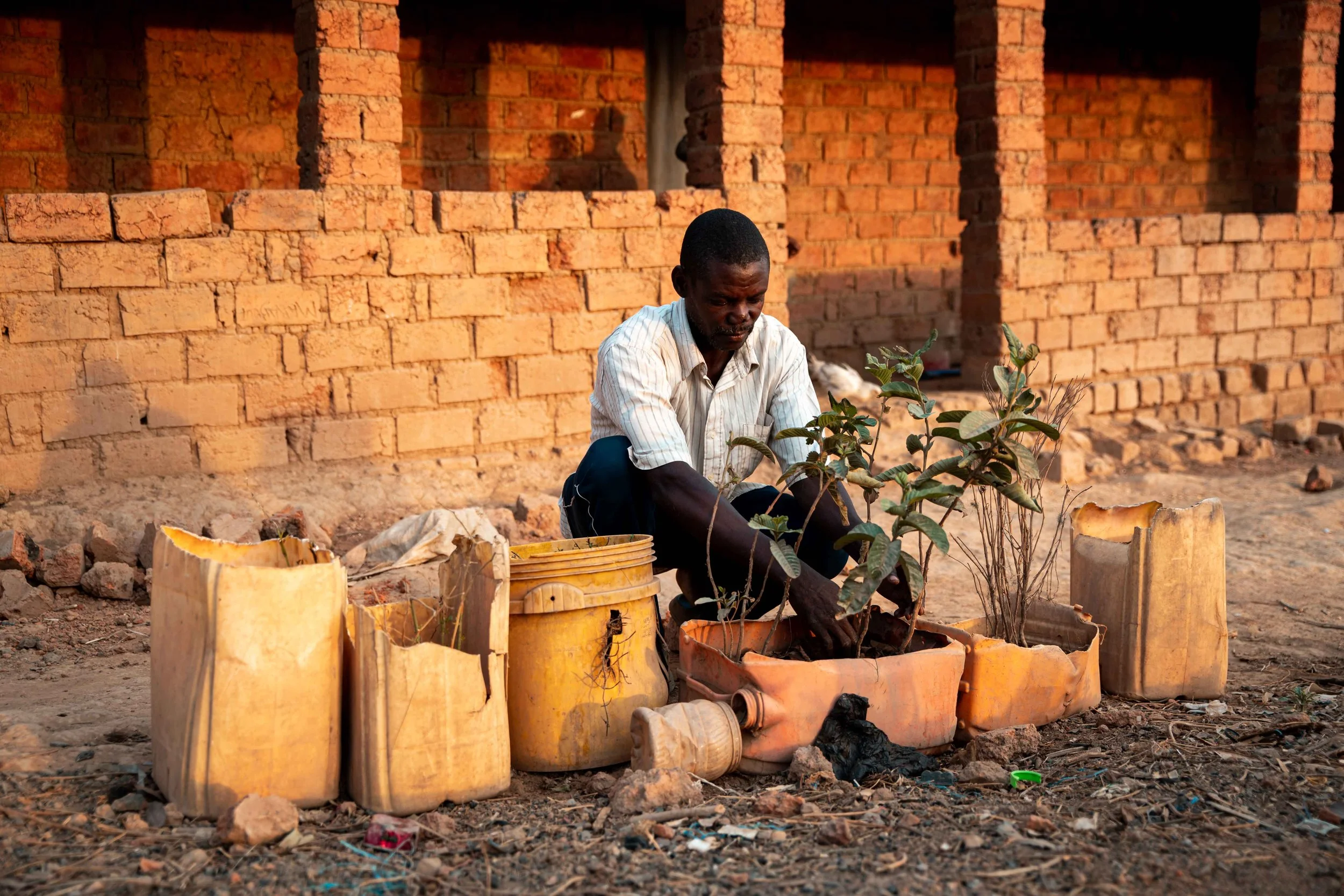 Kalonda Augustin tending his vegetable garden in front of his home. Fungurume, Lualaba Province, Democratic Republic of the Congo.