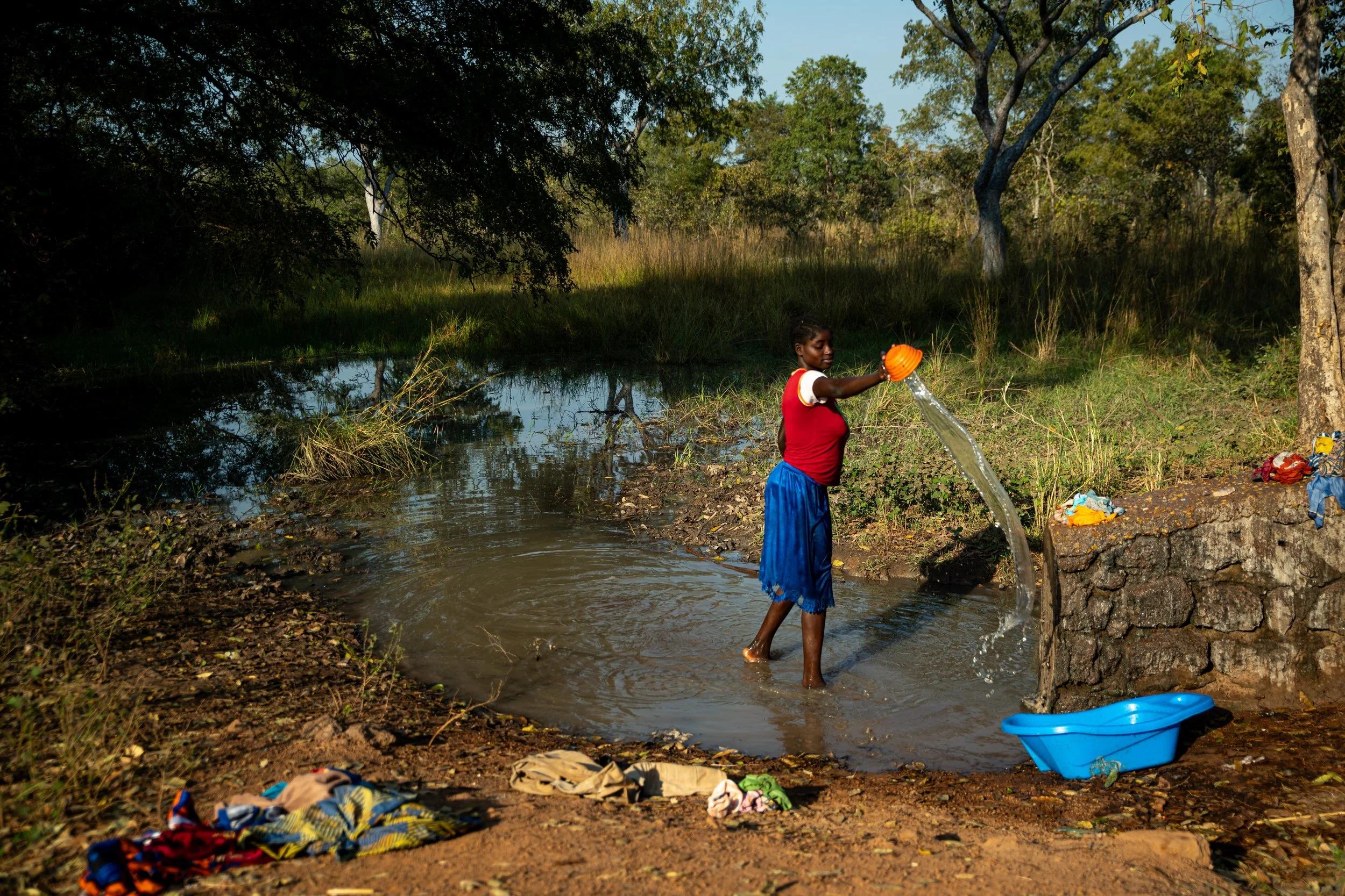 Une jeune fille en train de collecter de l’eau dans un marigot pour la lessive à Markounda, République centrafricaine, décembre 2025.