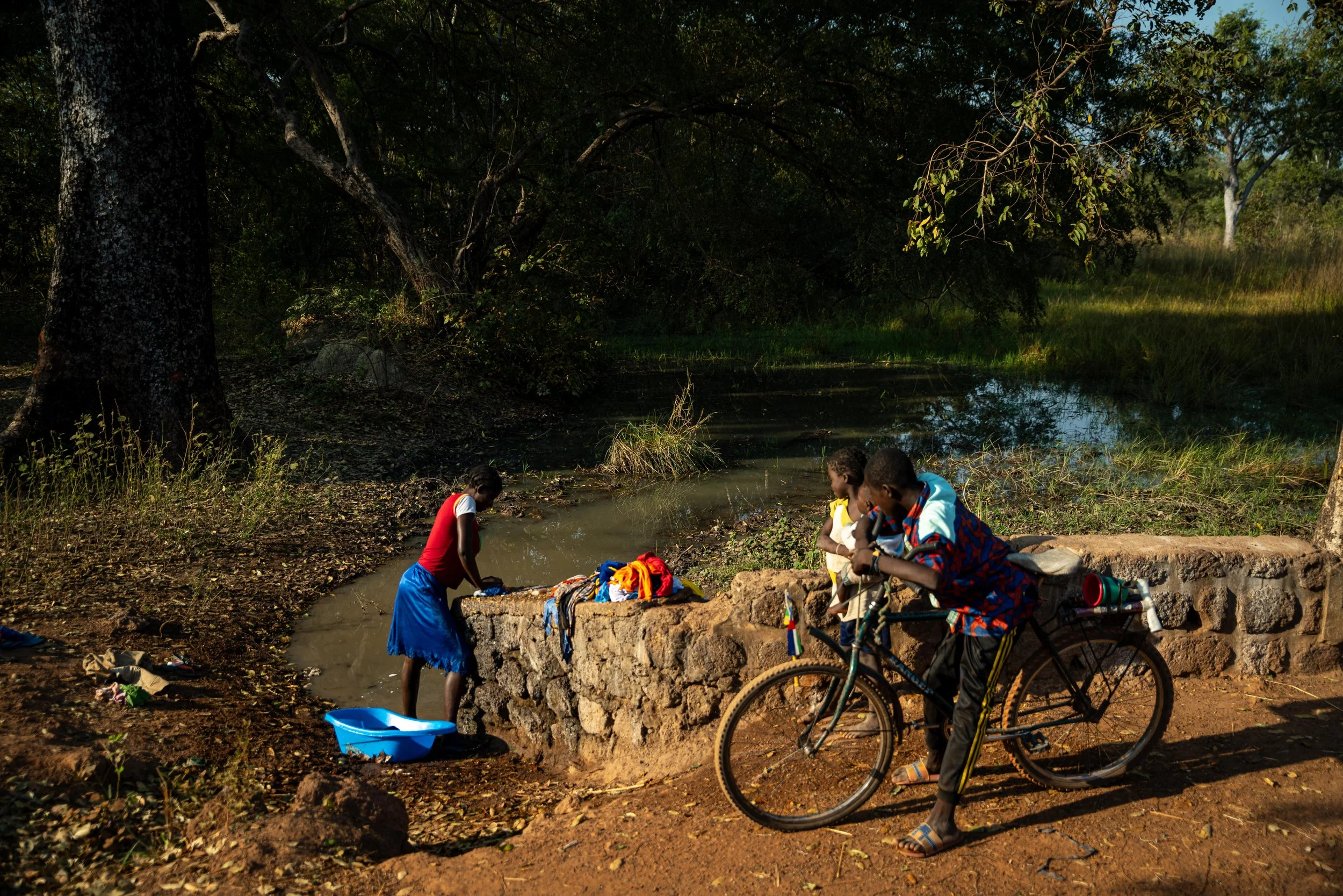 Une jeune fille en train de collecter de l’eau dans un marigot pour la lessive à Markounda, République centrafricaine, décembre 2025.