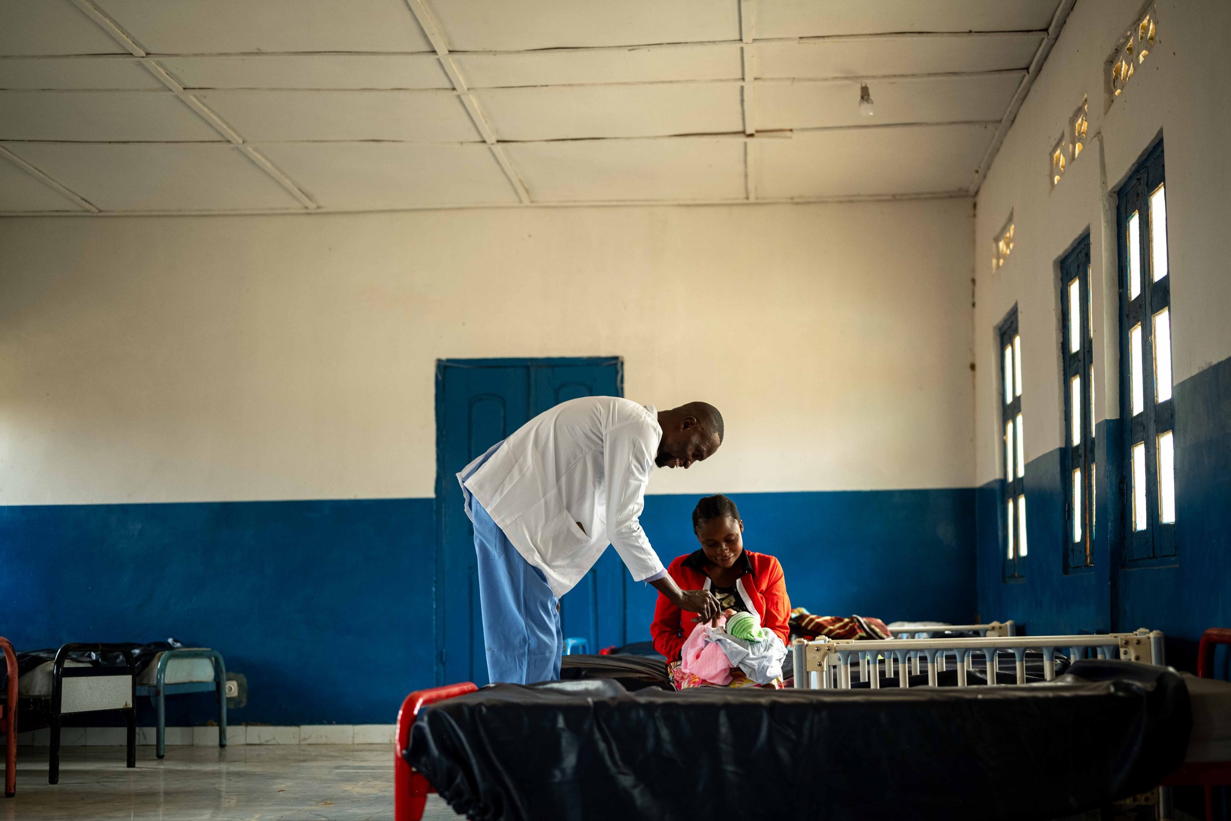 Dr. Bakumba Mupama visits Augustine Etomoni, 21, who gave birth two days earlier at the maternity clinic built by Mbou Mon Tour, Mai-Ndombe, Democratic Republic of Congo, August 2025.