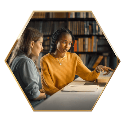 Two women looking at a computer, in a hexagon frame.