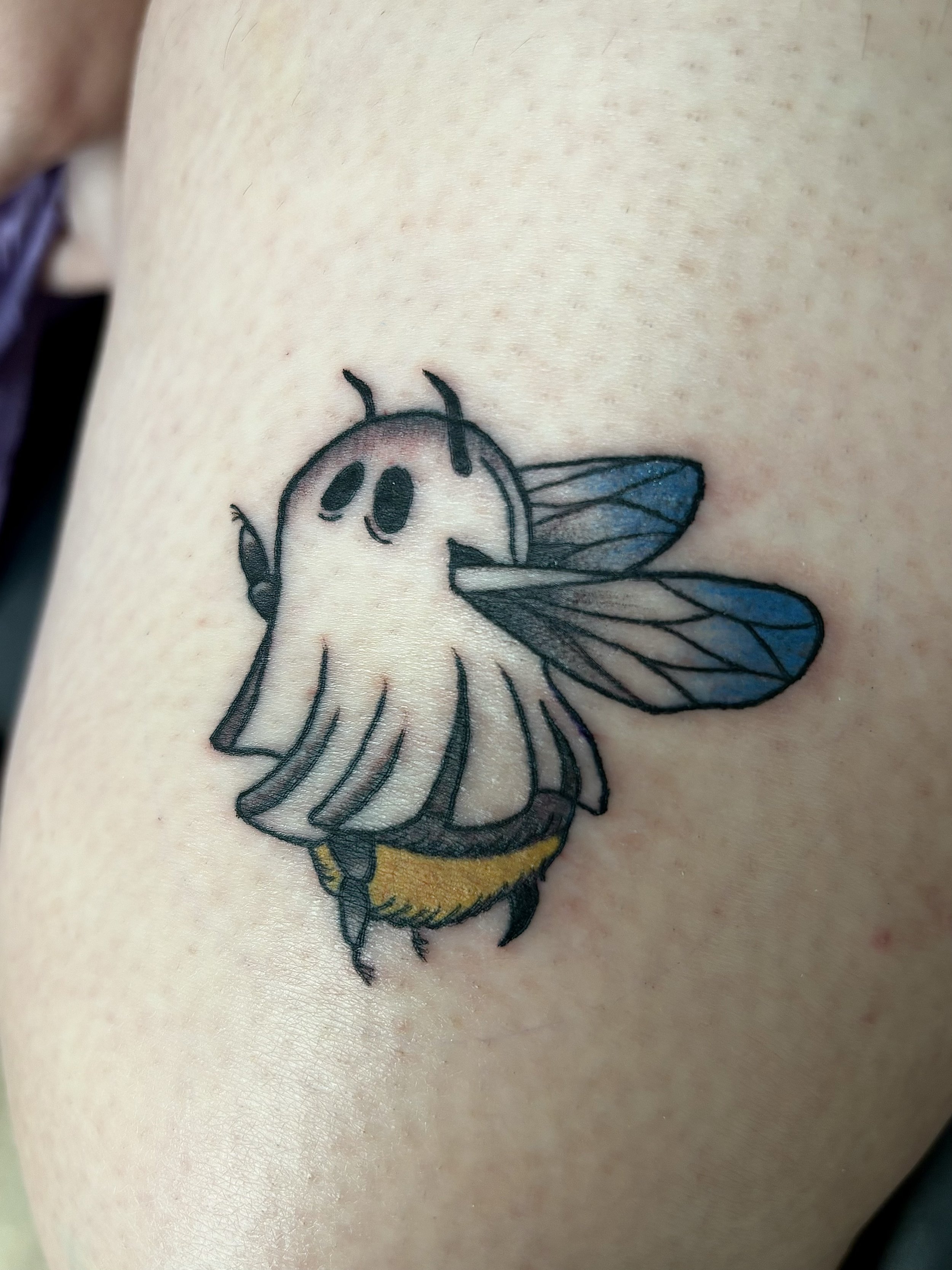 Tattoo of a ghost bee with wings and antennae on skin